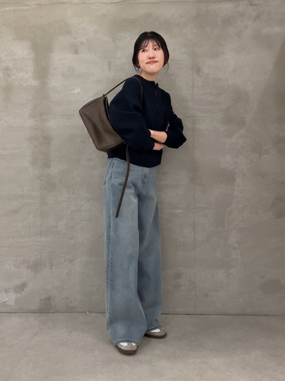 グレー系のニット/セーター、ブルー系のデニムパンツを着用したレディースの冬コーディネートの4枚目の写真