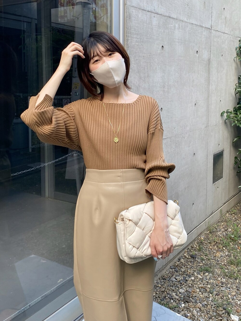 ホワイト系のショルダーバッグ、ベージュ系のスカートを着用したレディースの秋コーディネートの4枚目の写真