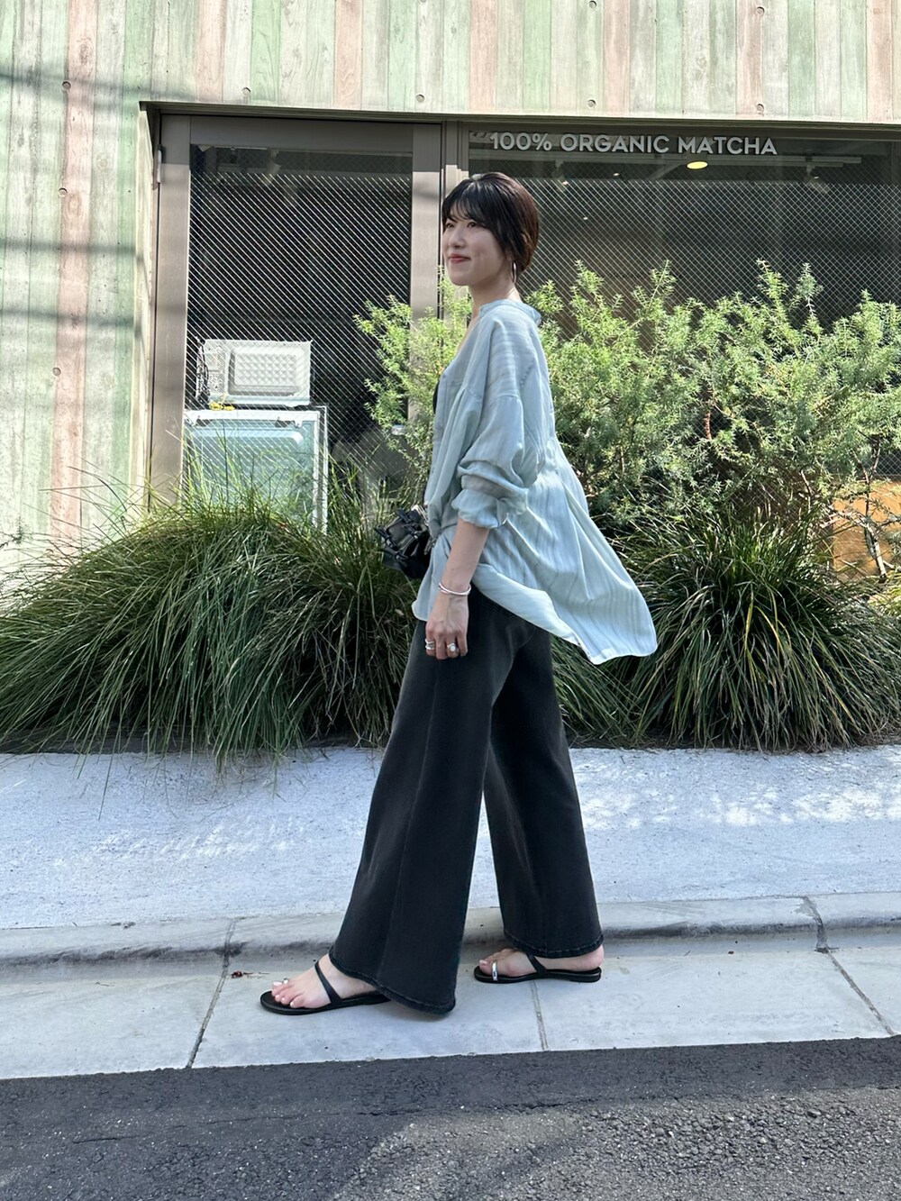 グリーン系のシャツ/ブラウス、ブラック系のデニムパンツ、ブラック系のショルダーバッグを着用したレディースの夏コーディネートの5枚目の写真