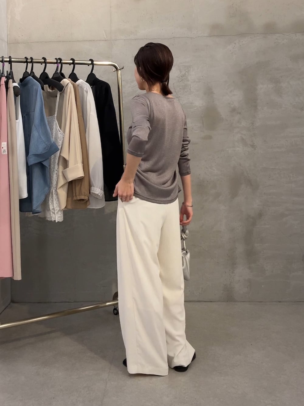 グレー系のカーディガン/ボレロ、ブラック系のサンダル、ホワイト系のスラックスを着用したレディースの春コーディネートの4枚目の写真