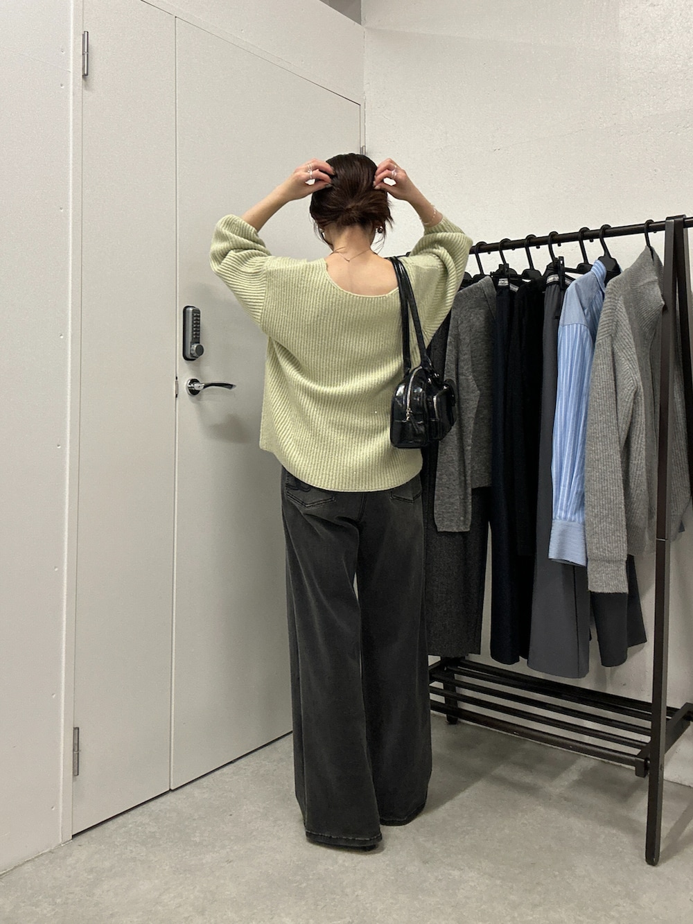 グリーン系のニット/セーター、ブラック系のデニムパンツ、シルバー系のネックレスを着用したレディースの秋コーディネートの3枚目の写真