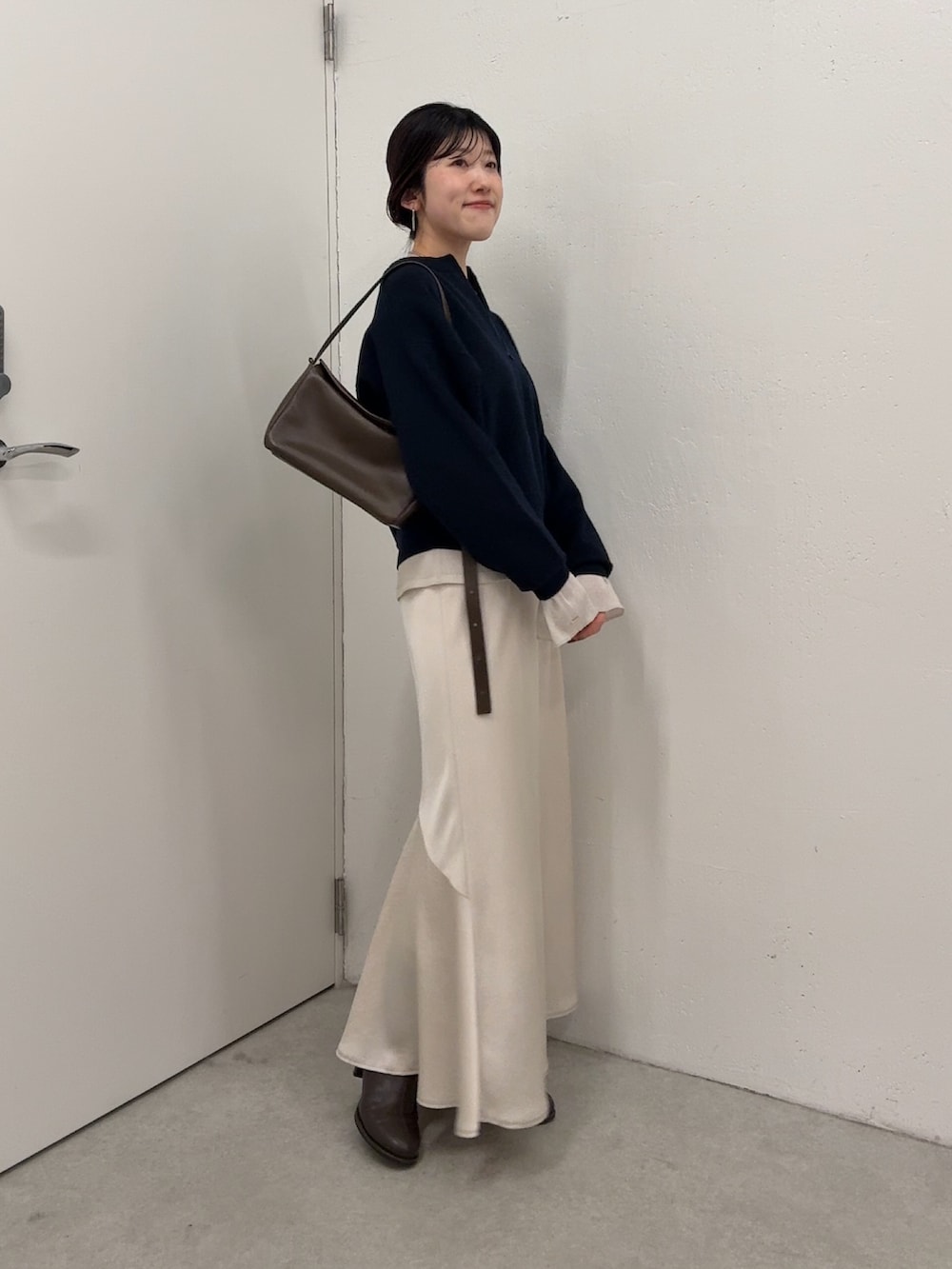 ブルー系のニット/セーター、ホワイト系のTシャツ/カットソー、ホワイト系のスカートを着用したレディースの冬コーディネートの2枚目の写真