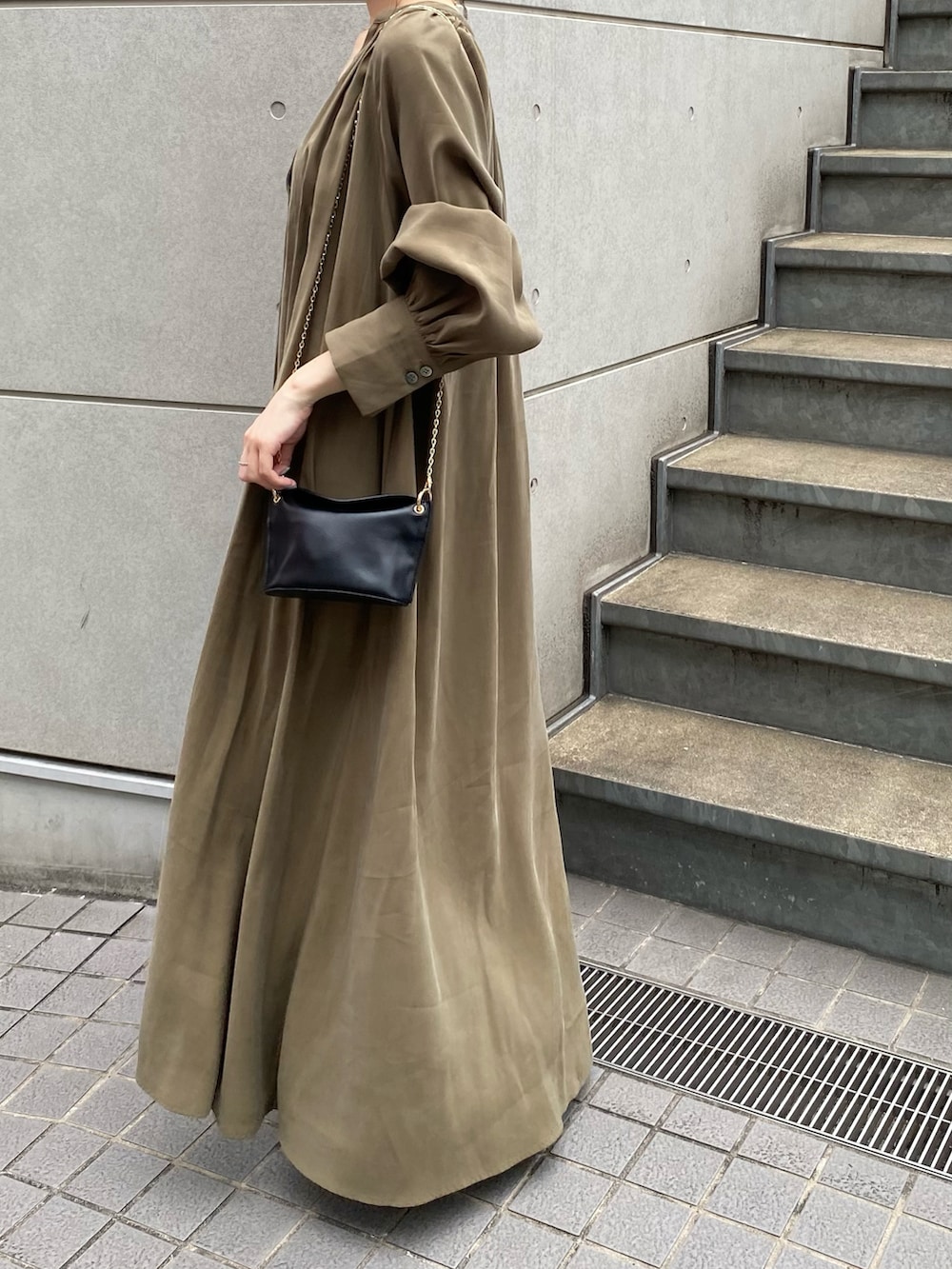 グリーン系のワンピース、ブラック系のブーツ、ブラック系のトートバッグを着用したレディースの夏コーディネートの3枚目の写真