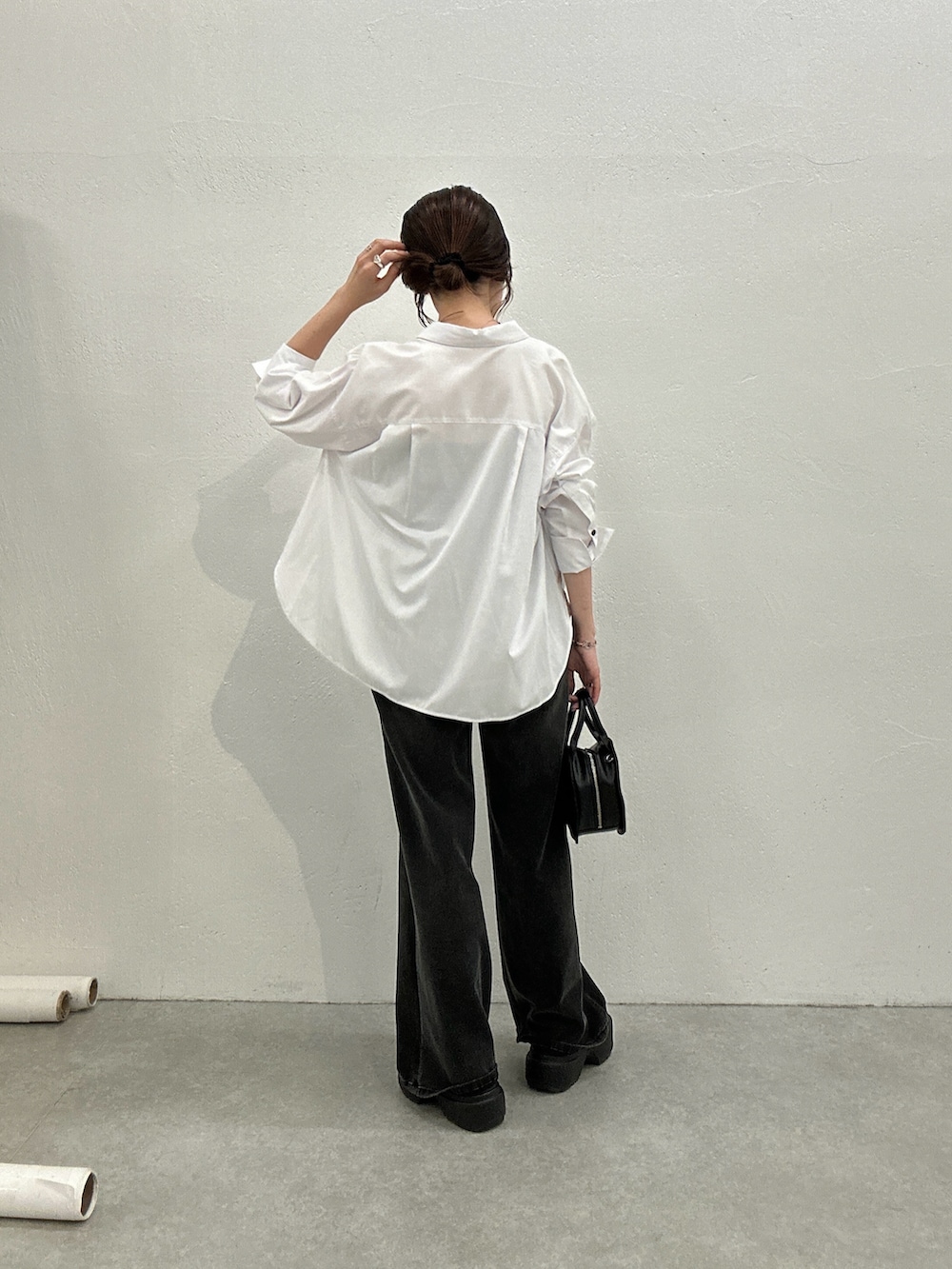 ホワイト系のシャツ/ブラウス、ブラック系のデニムパンツ、ブラック系のハンドバッグを着用したレディースの秋コーディネートの2枚目の写真