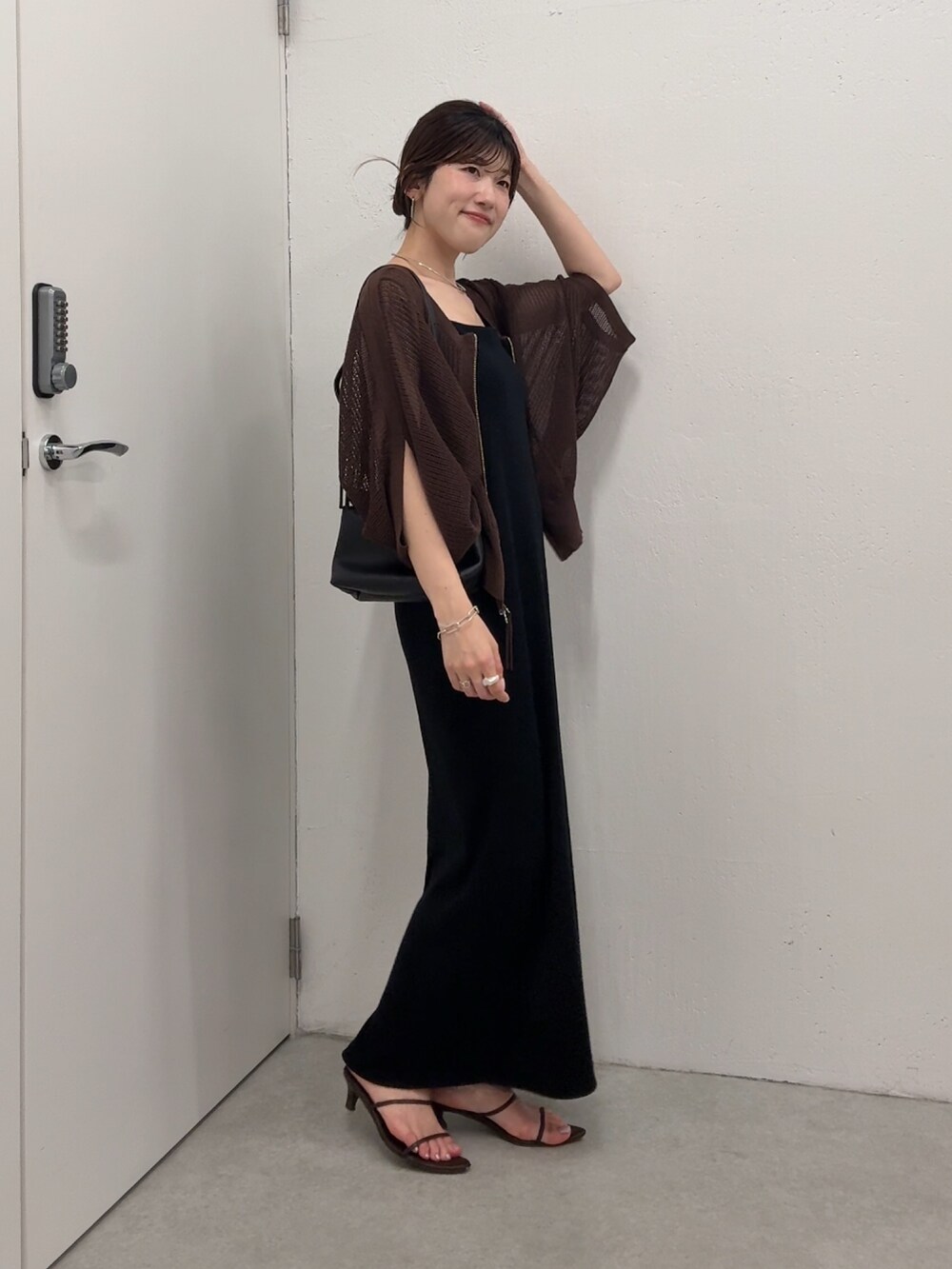ブラック系のワンピース、ブラウン系のカーディガン/ボレロ、ゴールド系のネックレスを着用したレディースの夏コーディネートの3枚目の写真
