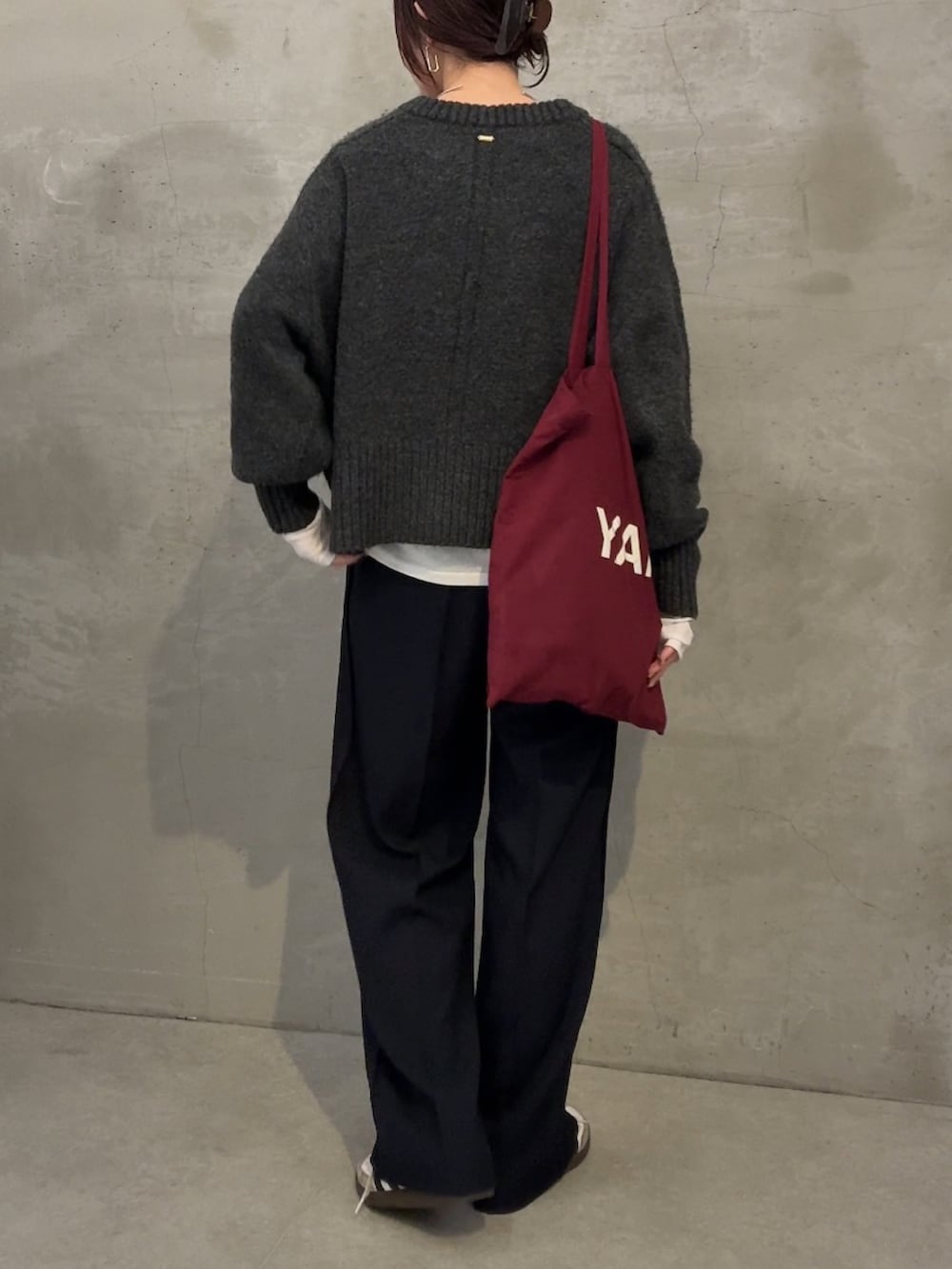 グレー系のニット/セーター、ホワイト系のTシャツ/カットソー、ブルー系のスラックスを着用したレディースの冬コーディネートの2枚目の写真