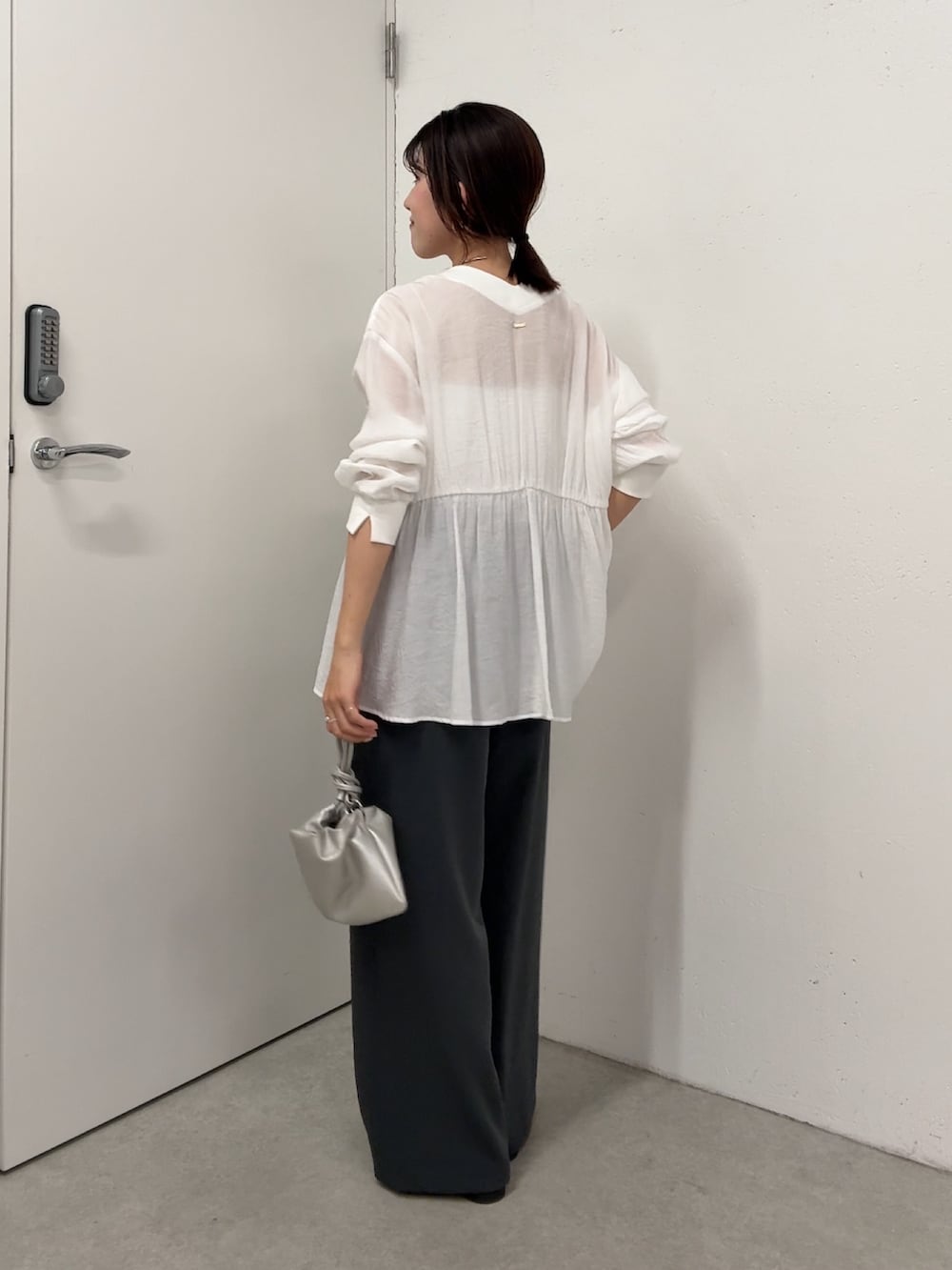 ホワイト系のシャツ/ブラウス、グレー系のスラックス、シルバー系のショルダーバッグを着用したレディースの春コーディネートの3枚目の写真