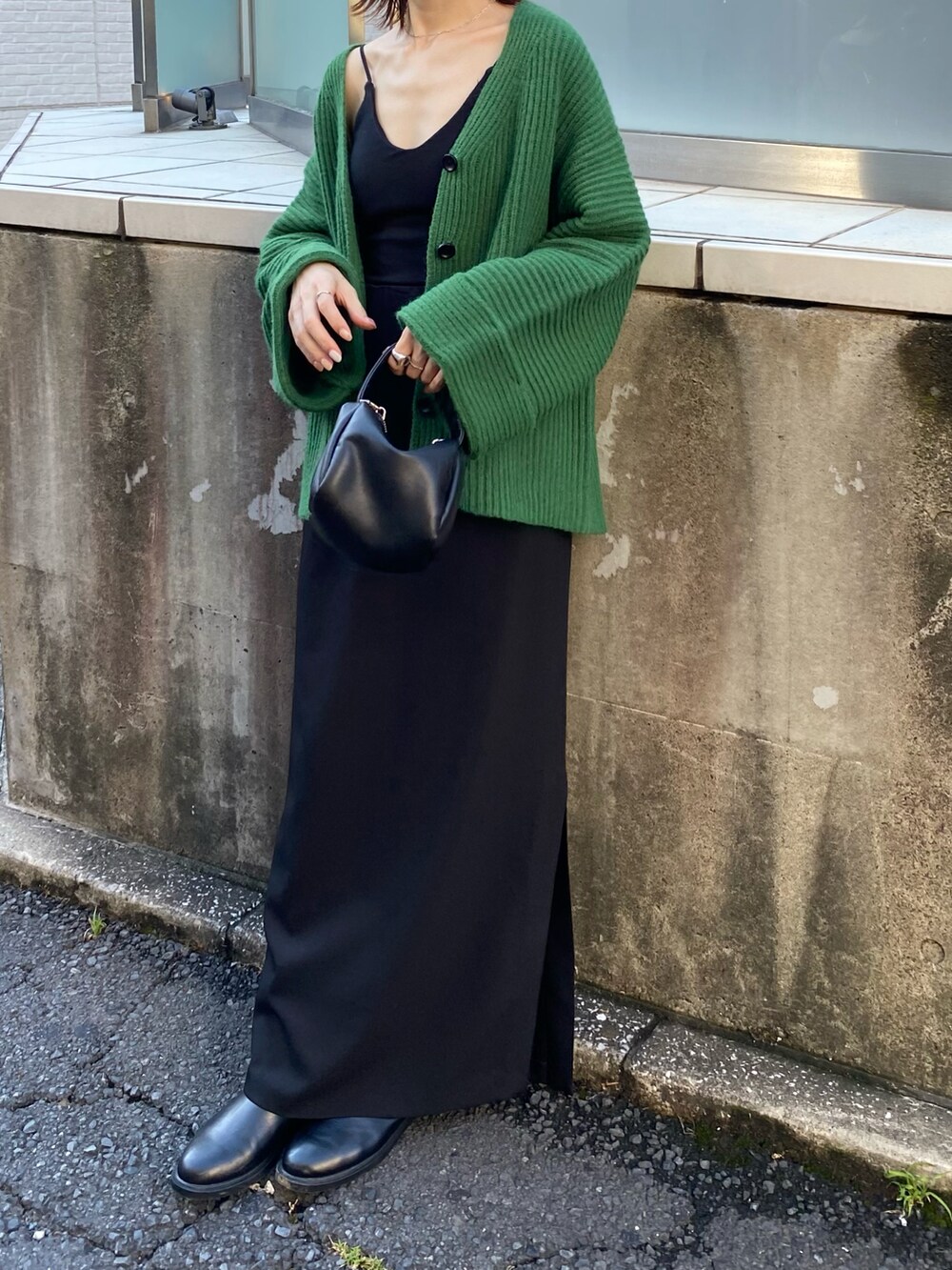 ブラック系のキャミソール、グリーン系のカーディガン/ボレロ、グリーン系のショルダーバッグを着用したレディースの夏コーディネートの3枚目の写真