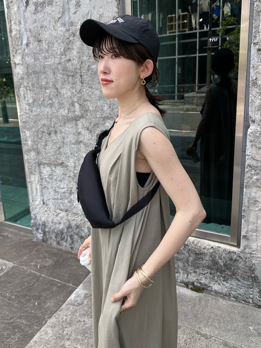 ブラック系のボディバッグ/ウエストポーチ、ブラック系のサンダル、ベージュ系のつなぎ/オールインワンを着用したレディースの春コーディネートの4枚目の写真