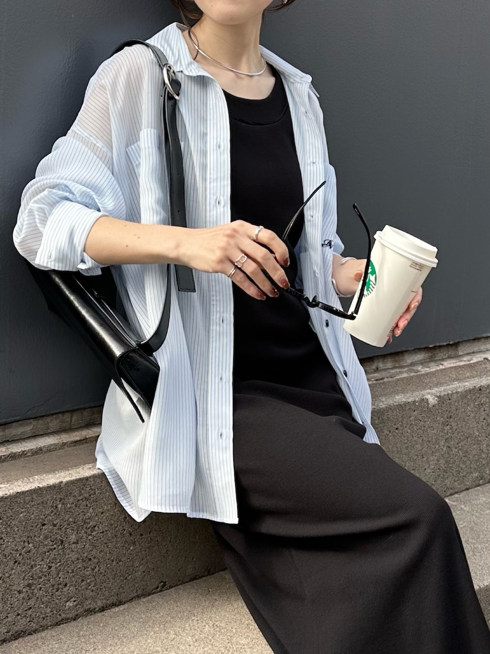 ブラック系のワンピース、ブルー系のシャツ/ブラウス、ブラック系のバッグを着用したレディースの春コーディネートの4枚目の写真