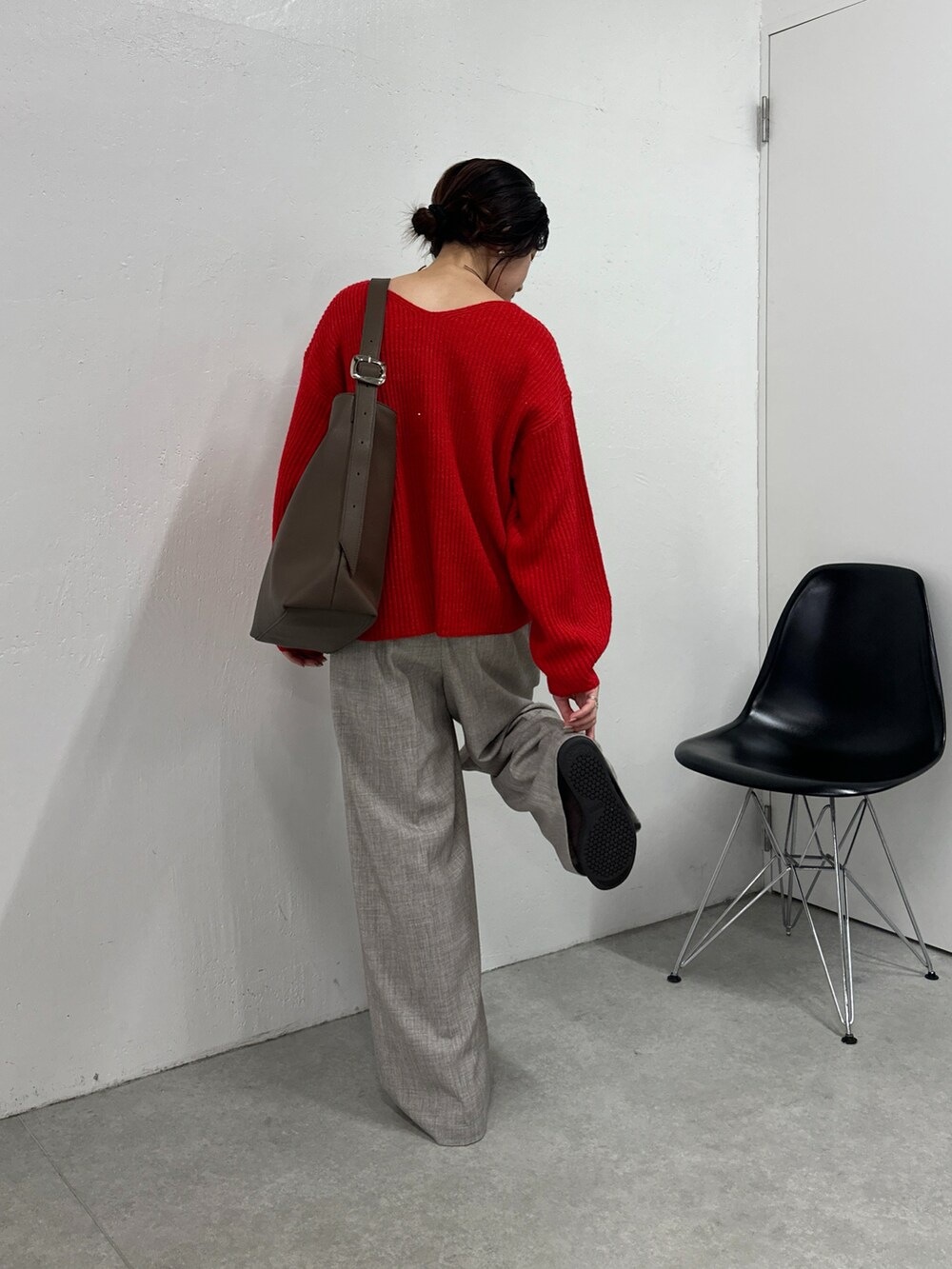 レッド系のニット/セーター、ベージュ系のその他パンツ、ブラウン系のバッグを着用したレディースの秋コーディネートの2枚目の写真