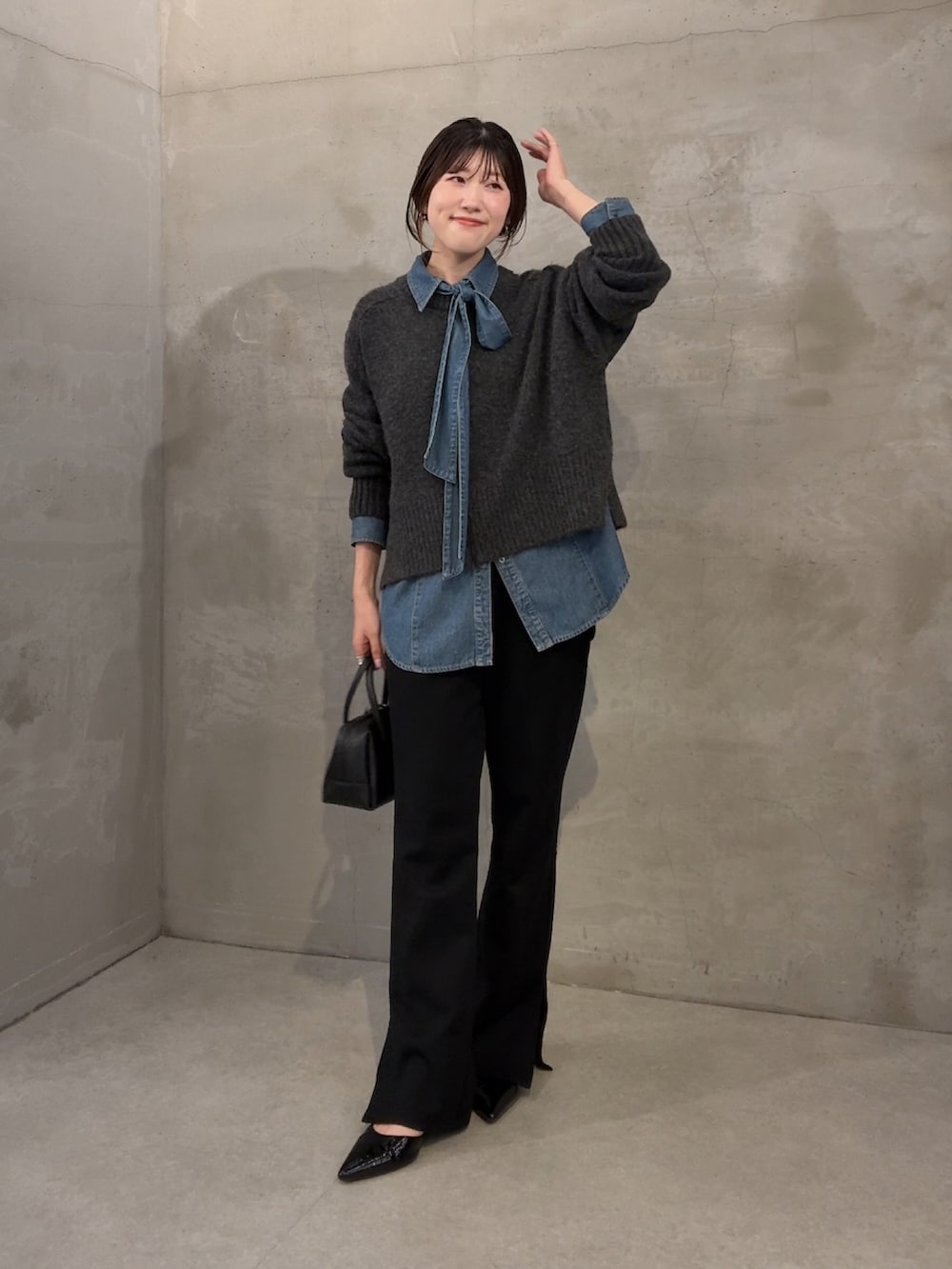 グレー系のニット/セーター、ブルー系のシャツ/ブラウス、ブラック系のその他パンツを着用したレディースの秋コーディネートの4枚目の写真