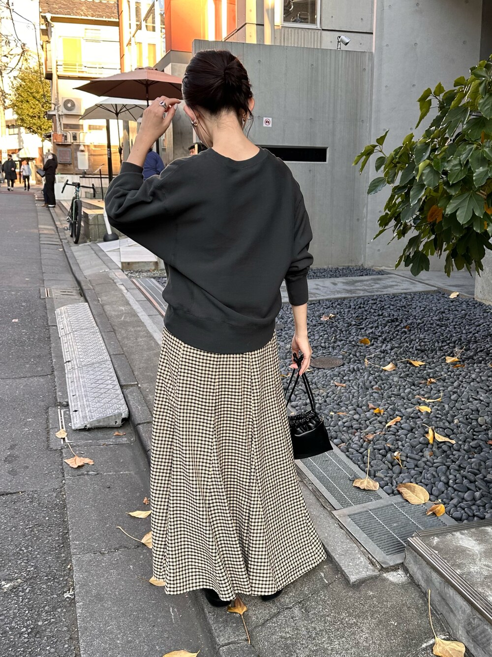 グレー系のスウェット、ベージュ系のスカート、ブラック系のショルダーバッグを着用したレディースの秋コーディネートの5枚目の写真