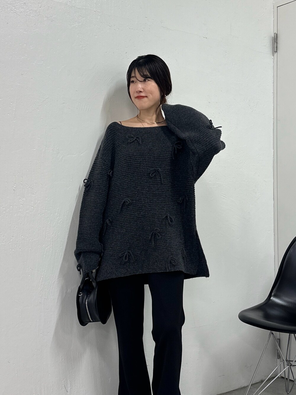 グレー系のニット/セーター、ブラック系のその他パンツ、ブラック系のハンドバッグを着用したレディースの秋コーディネートの2枚目の写真