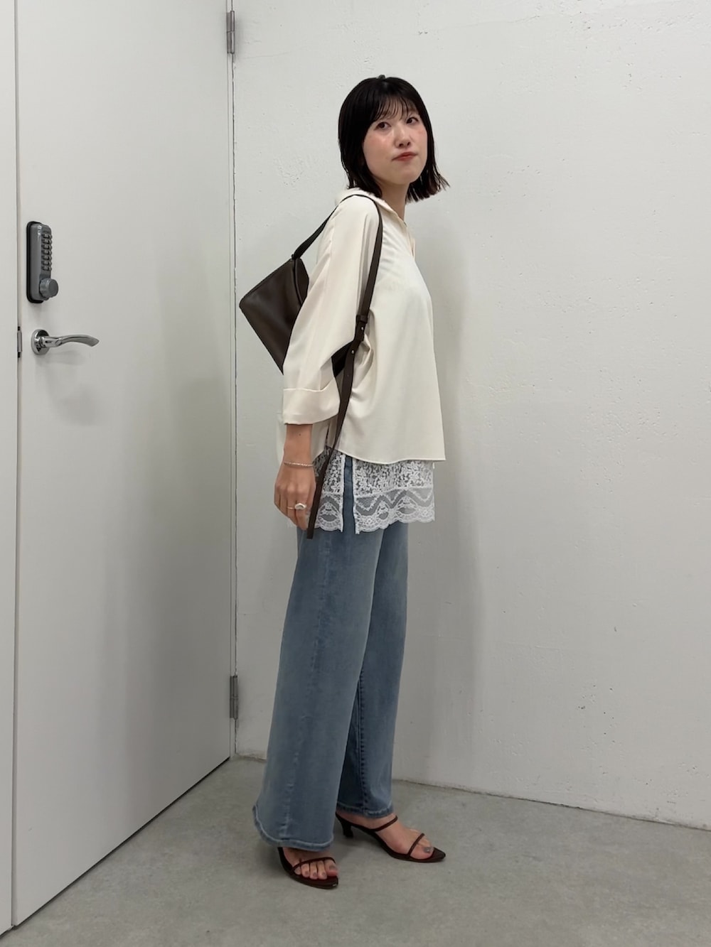 ホワイト系のシャツ/ブラウス、ホワイト系のキャミソール、ブルー系のデニムパンツを着用したレディースの春コーディネートの2枚目の写真