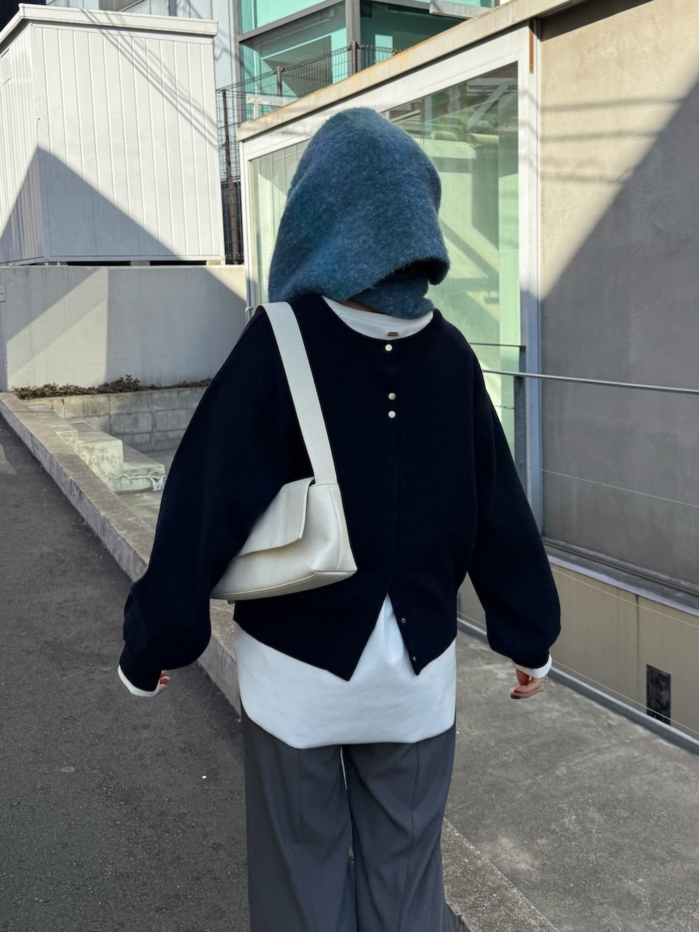 ブルー系のニット/セーター、グレー系のその他パンツ、ホワイト系のTシャツ/カットソーを着用したレディースの冬コーディネートの3枚目の写真