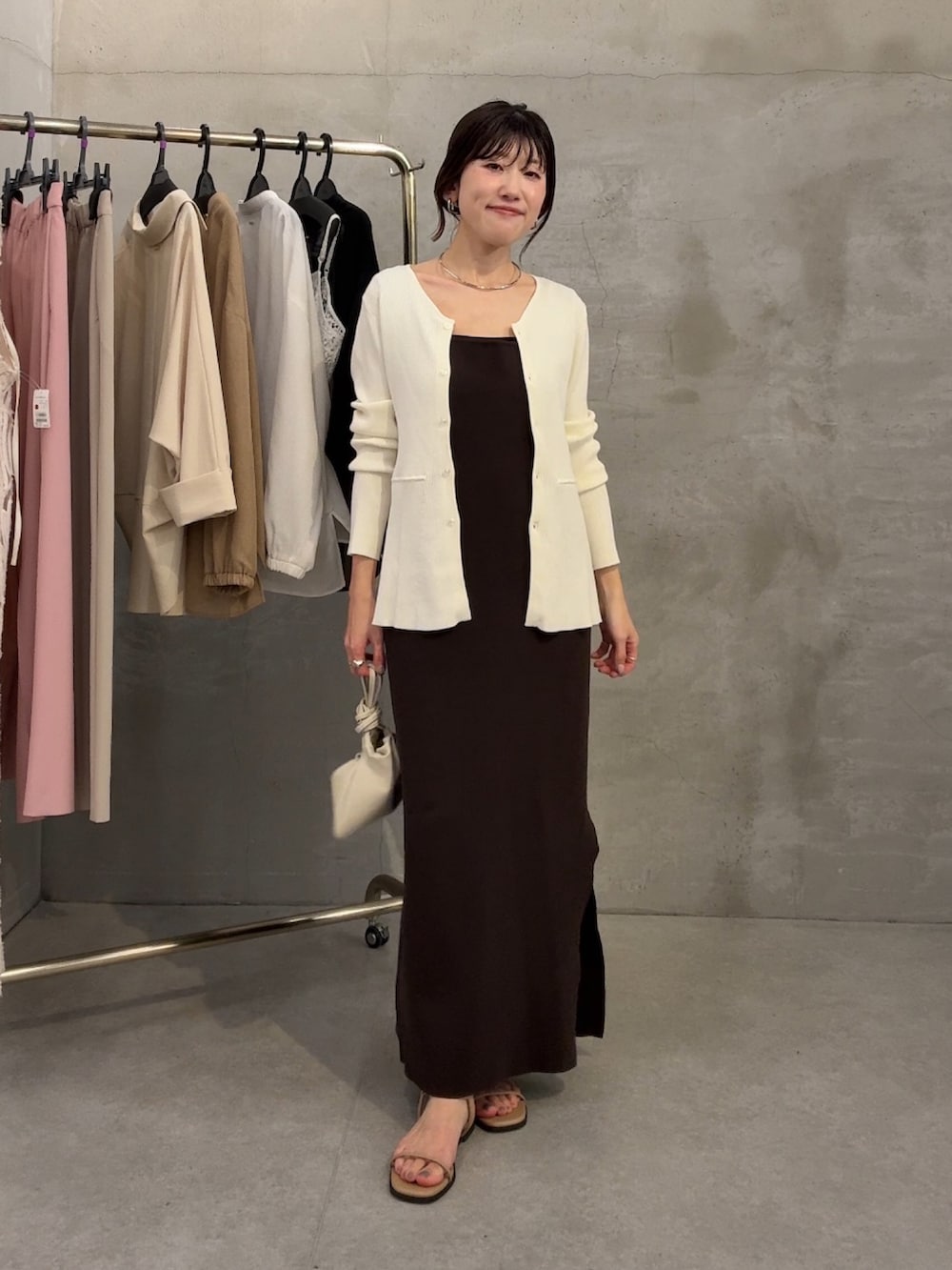 ホワイト系のカーディガン/ボレロ、ブラウン系のワンピース、ホワイト系のショルダーバッグを着用したレディースの春コーディネートの2枚目の写真