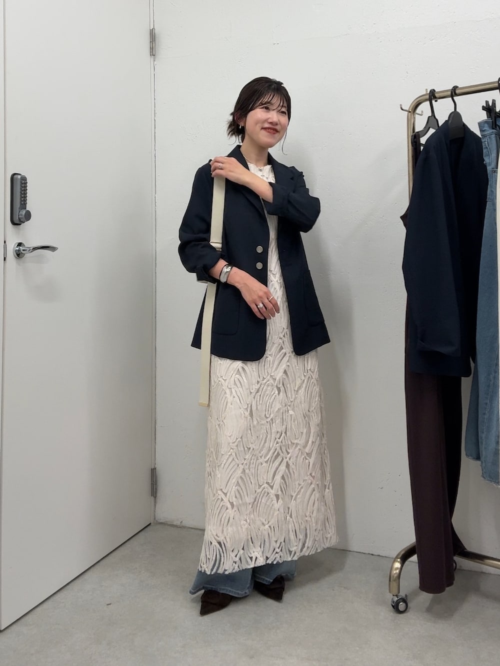 ブルー系のテーラードジャケット、ホワイト系のワンピース/ドレス、ホワイト系のバッグを着用したレディースの春コーディネートの4枚目の写真