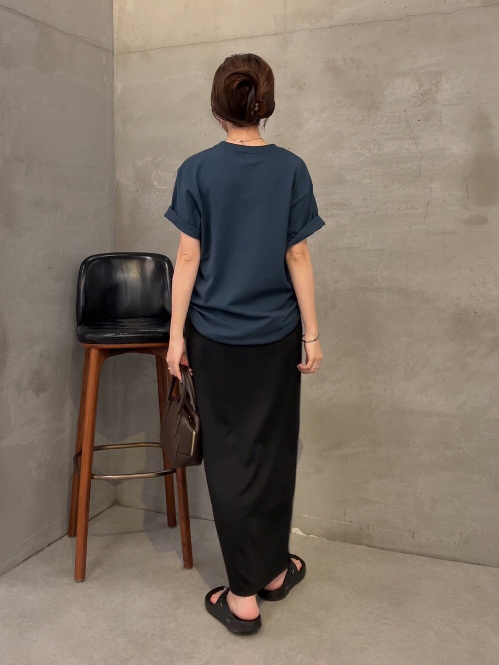 ブルー系のTシャツ/カットソー、ブラック系のスカート、ブラウン系のショルダーバッグを着用したレディースの夏コーディネートの2枚目の写真