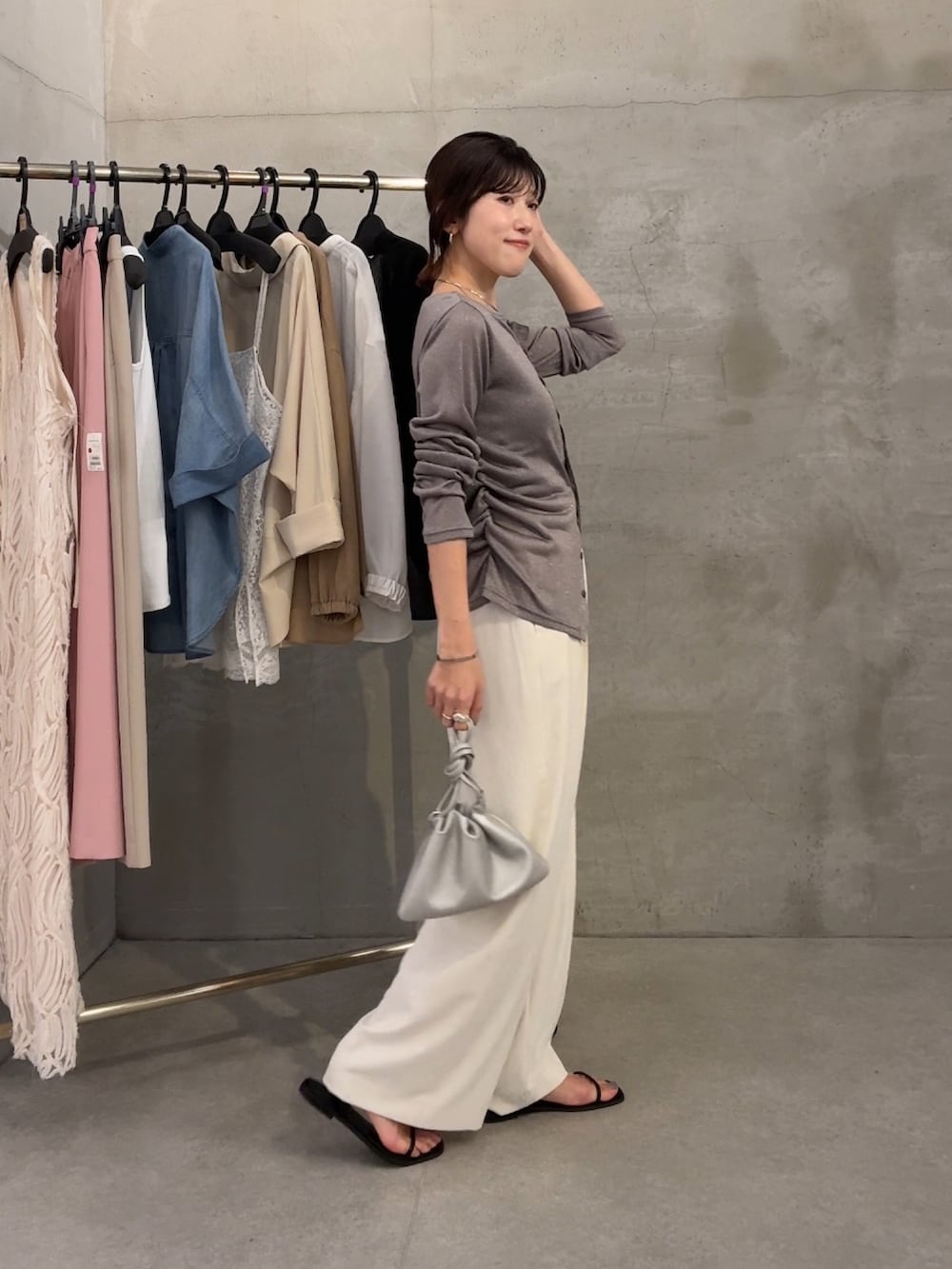 グレー系のカーディガン/ボレロ、ブラック系のサンダル、ホワイト系のスラックスを着用したレディースの春コーディネートの3枚目の写真
