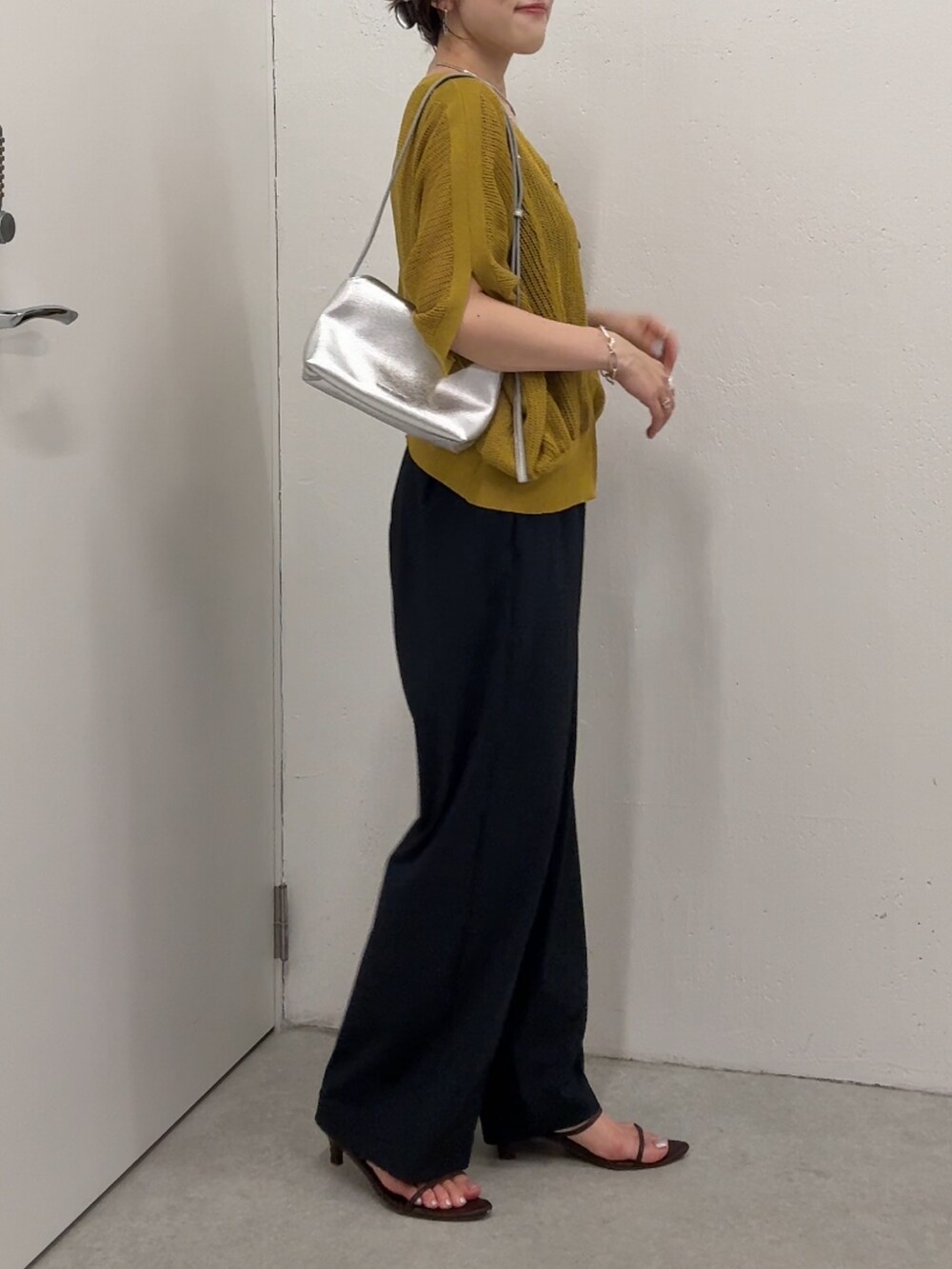 イエロー系のカーディガン/ボレロ、ブラック系のその他パンツ、シルバー系のショルダーバッグを着用したレディースの夏コーディネートの4枚目の写真