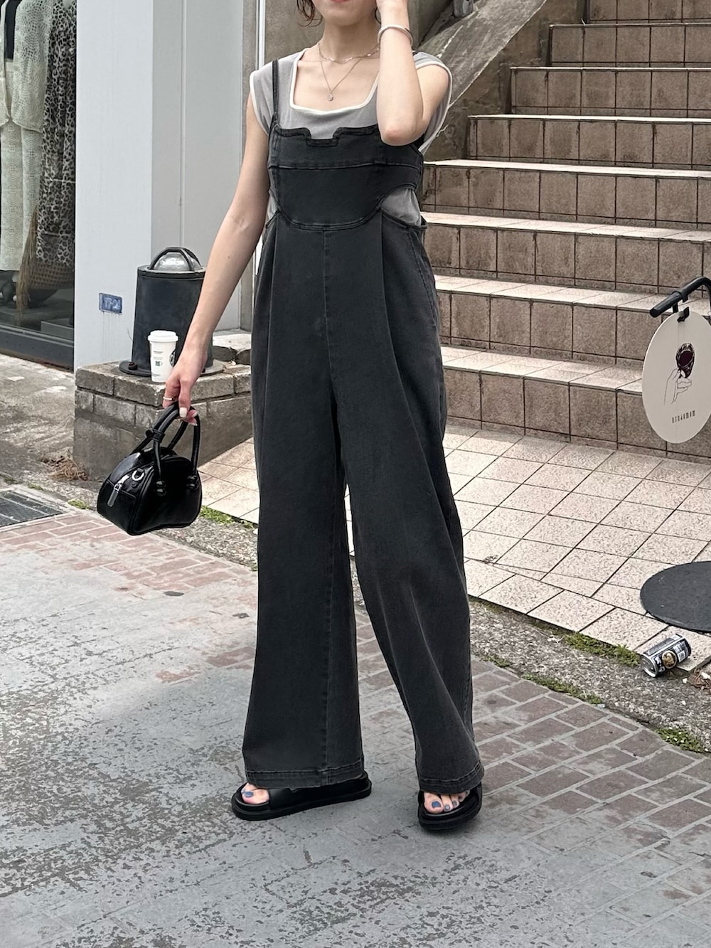 ブラック系のつなぎ/オールインワン、ブラック系のバッグ、グレー系のTシャツ/カットソーを着用したレディースの春コーディネートの2枚目の写真
