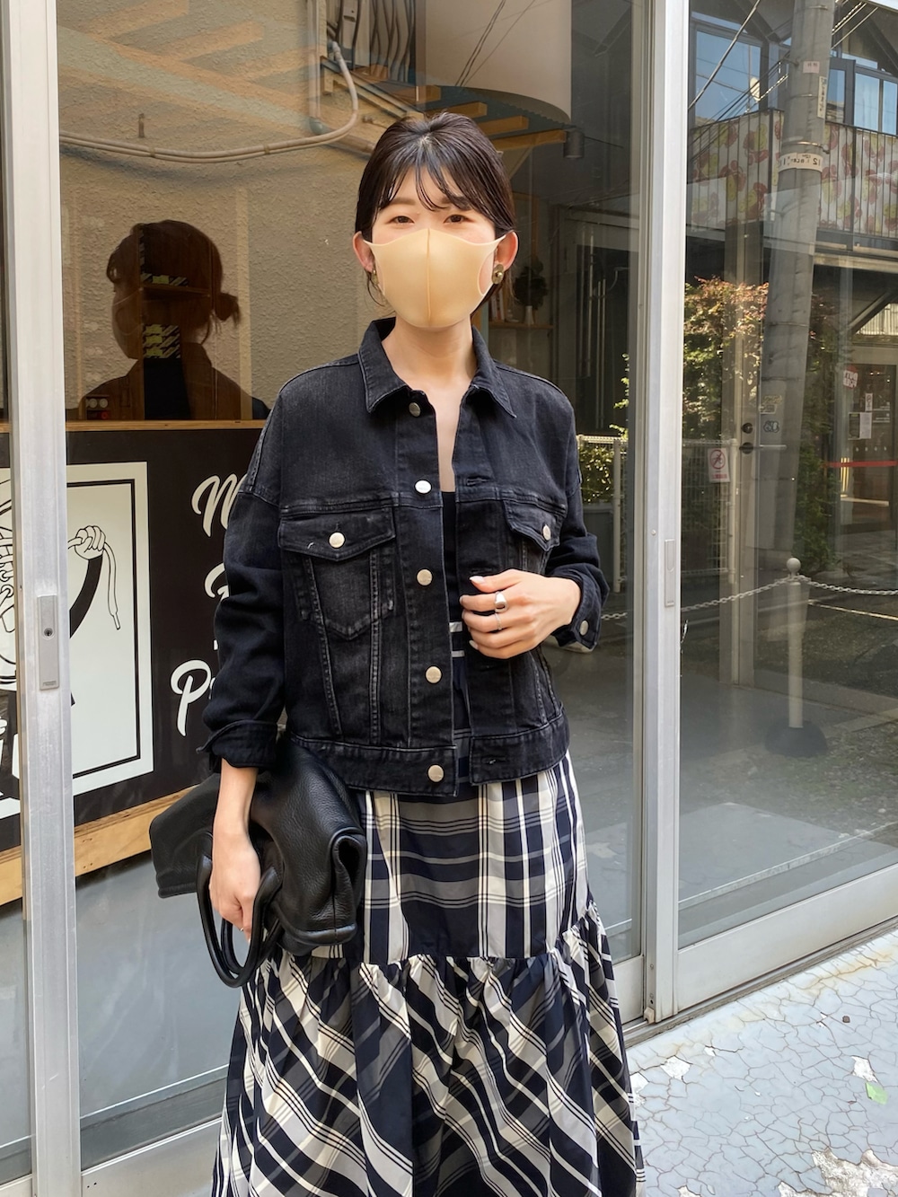 ブラック系のトートバッグ、ブラック系のスカート、ブラック系のデニムジャケットを着用したレディースの秋コーディネートの5枚目の写真