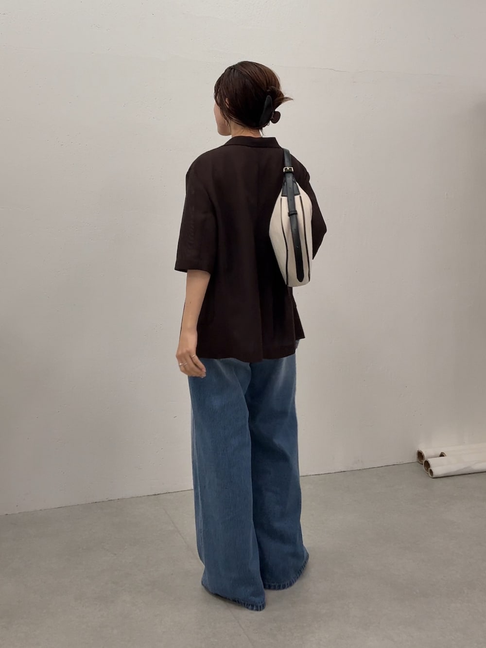 ブラウン系のテーラードジャケット、ブルー系のデニムパンツ、ゴールド系のネックレスを着用したレディースの夏コーディネートの3枚目の写真