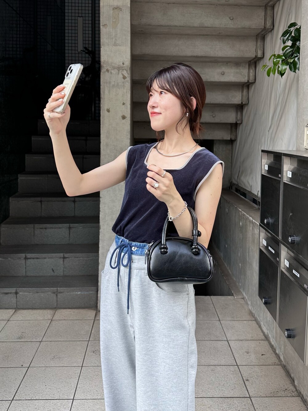 ブルー系のTシャツ/カットソー、グレー系のデニムパンツ、ブラック系のバッグを着用したレディースの夏コーディネートの4枚目の写真