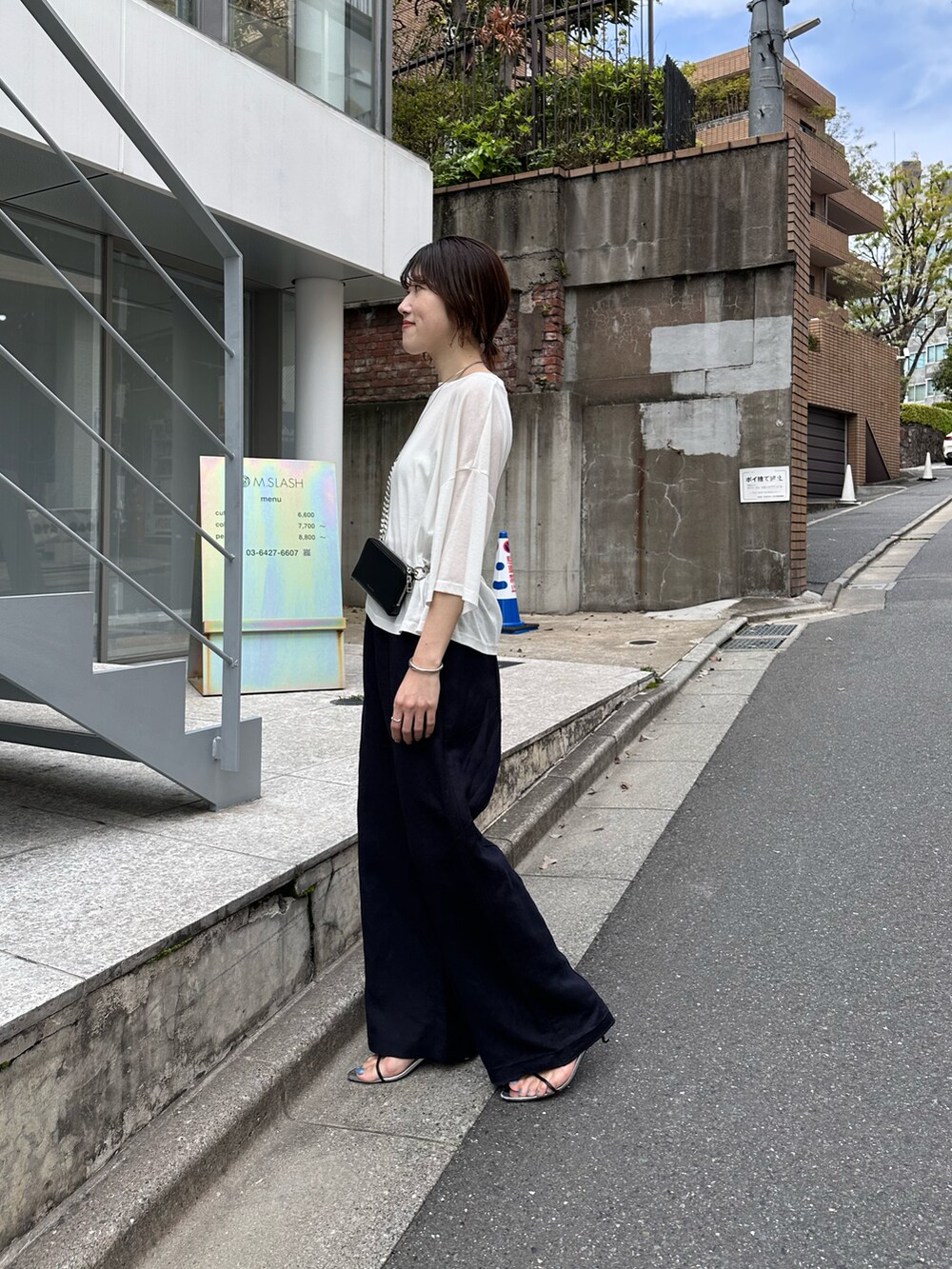 ホワイト系のTシャツ/カットソー、ブラック系のショルダーバッグ、ブルー系のスラックスを着用したレディースの春コーディネートの2枚目の写真