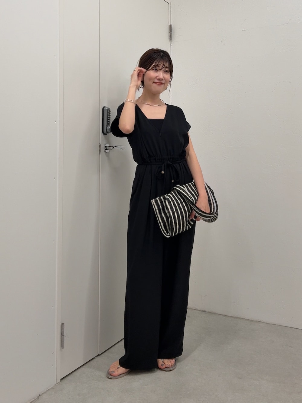 ブラック系のつなぎ/オールインワン、ブラック系のトートバッグ、ゴールド系のネックレスを着用したレディースの春コーディネートの4枚目の写真