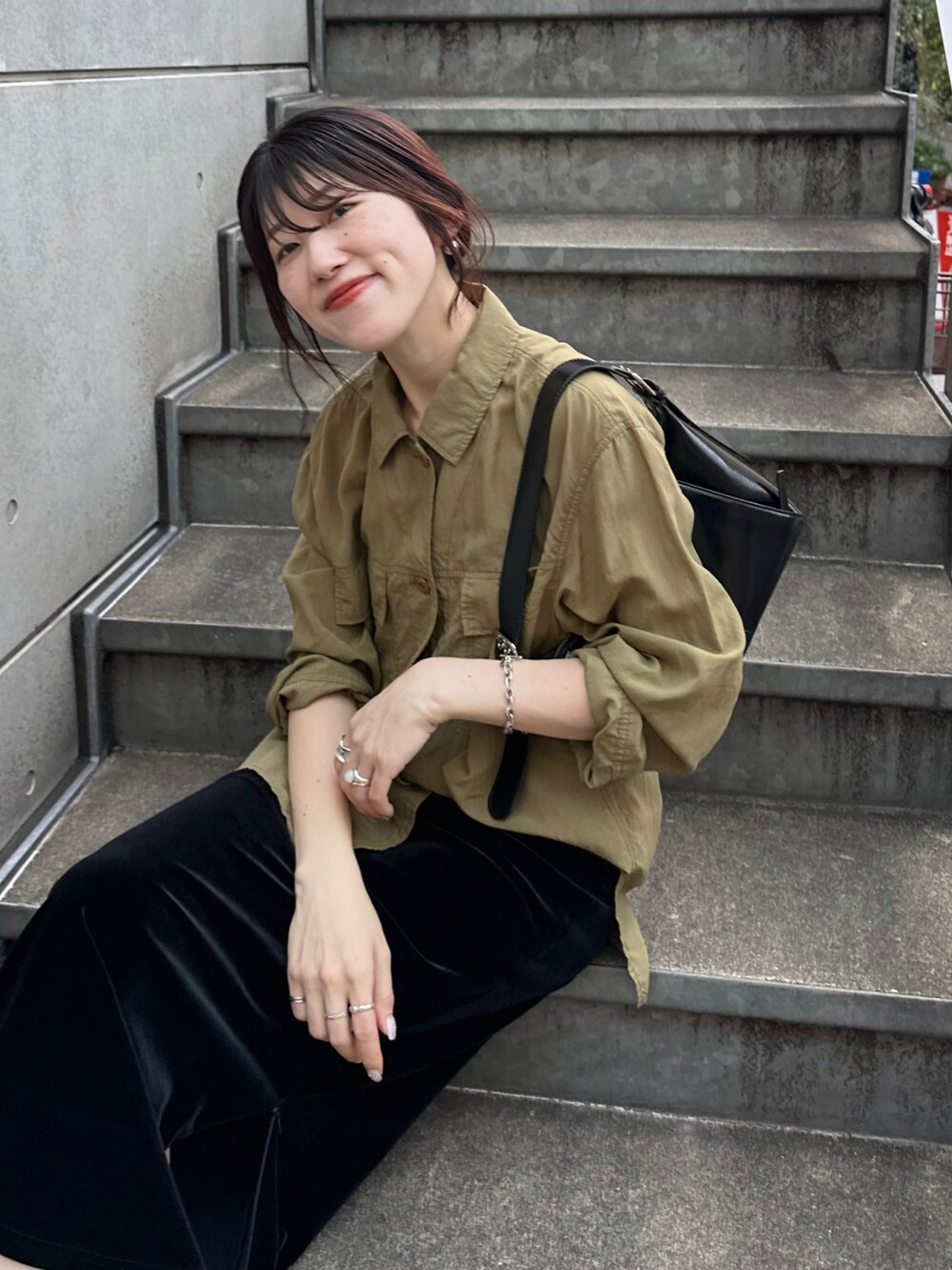 グリーン系のシャツ/ブラウス、ブラック系のスカート、ブラック系のバッグを着用したレディースの秋コーディネートの3枚目の写真