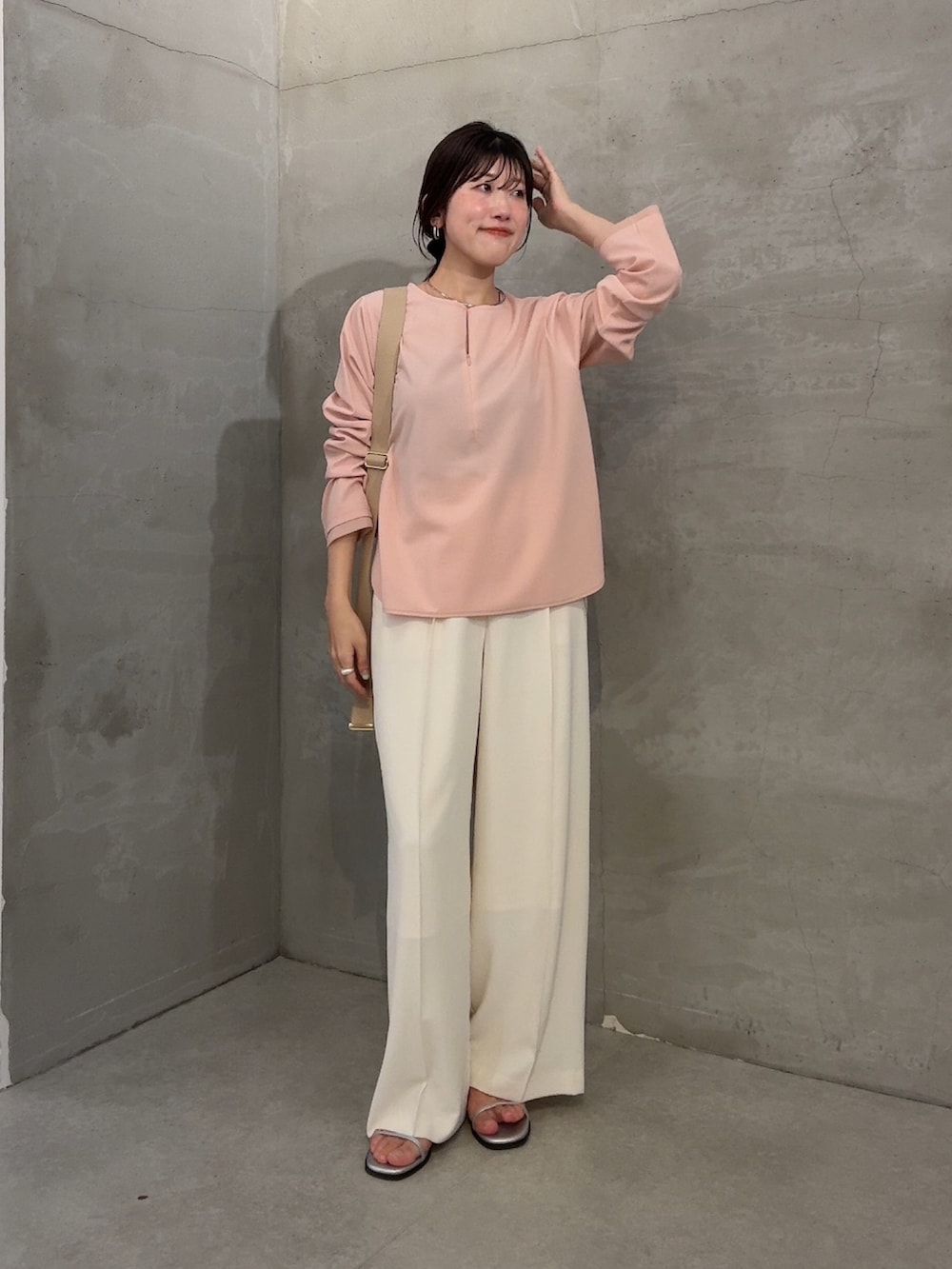 ピンク系のTシャツ/カットソー、ホワイト系のスラックス、ベージュ系のショルダーバッグを着用したレディースの冬コーディネートの4枚目の写真