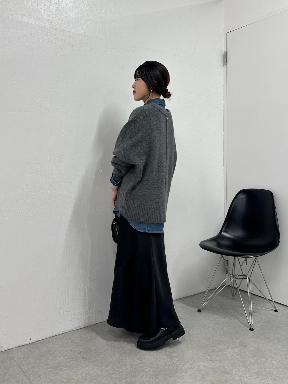 グレー系のニット/セーター、ブルー系のシャツ/ブラウス、ブルー系のスカートを着用したレディースの秋コーディネートの2枚目の写真