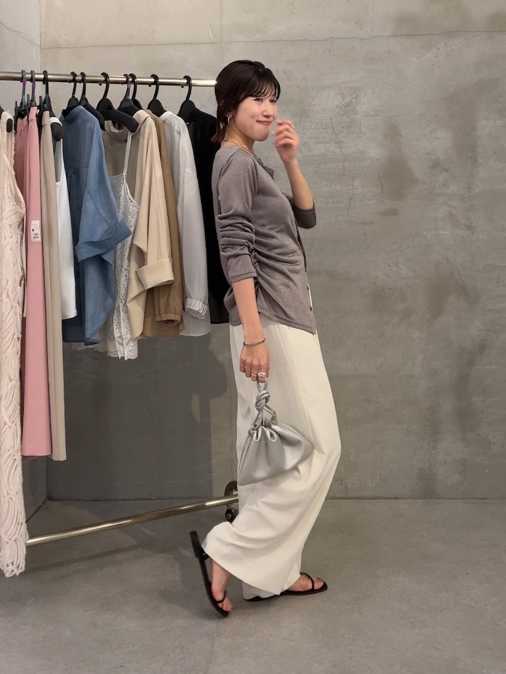 グレー系のカーディガン/ボレロ、ブラック系のサンダル、ホワイト系のスラックスを着用したレディースの春コーディネートの2枚目の写真
