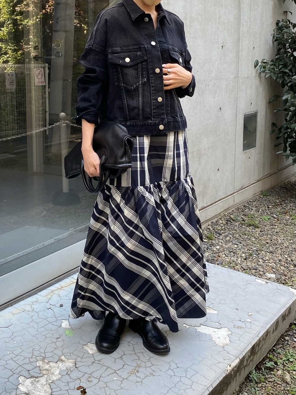 ブラック系のトートバッグ、ブラック系のスカート、ブラック系のデニムジャケットを着用したレディースの秋コーディネートの2枚目の写真