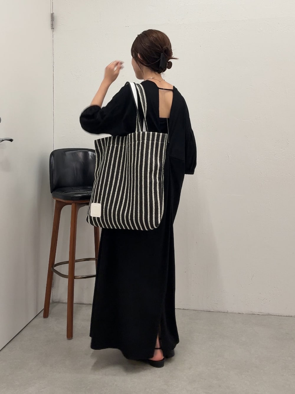 ブラック系のワンピース、ブラック系のトートバッグを着用したレディースの春コーディネートの2枚目の写真