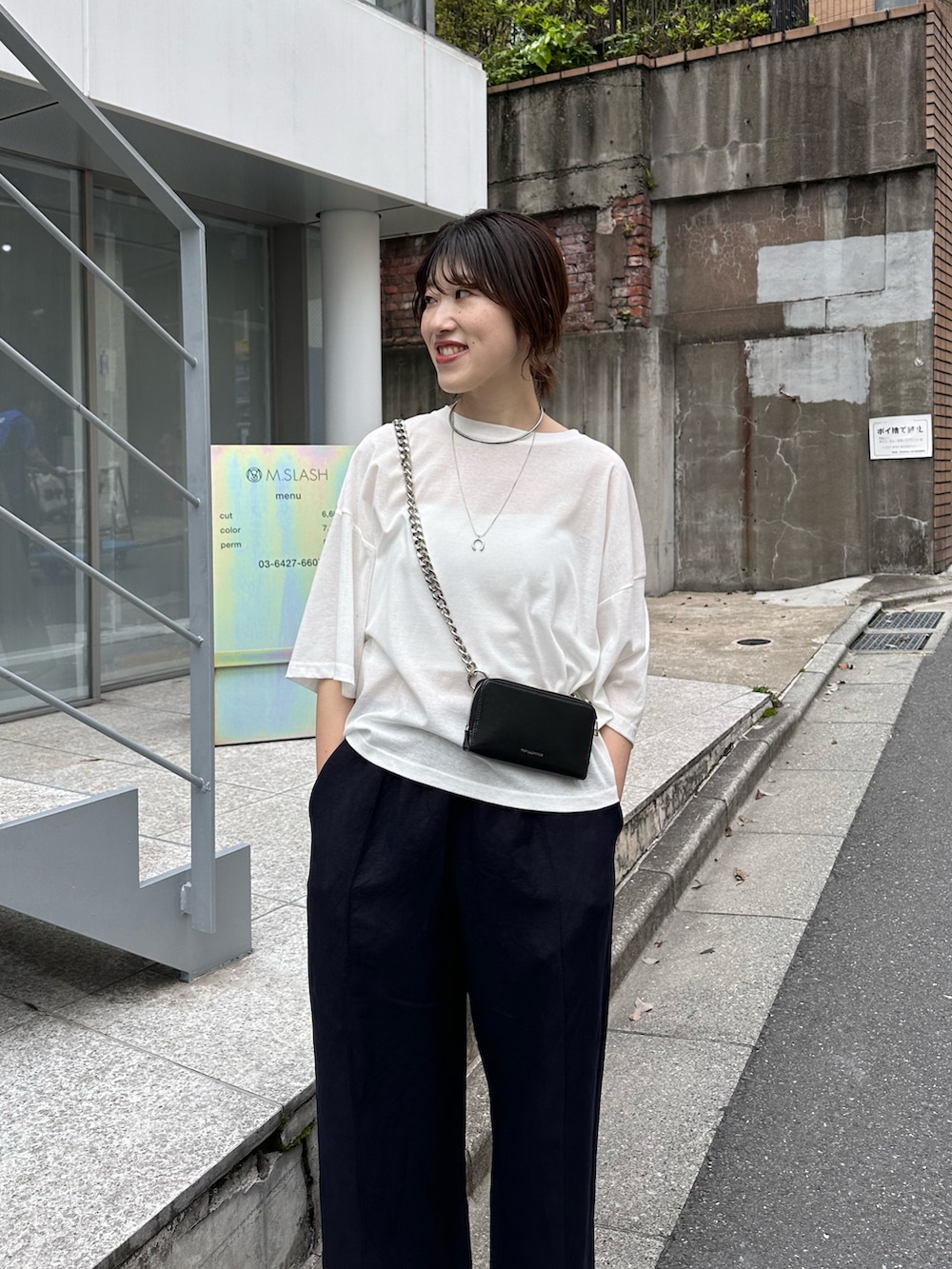 ホワイト系のTシャツ/カットソー、ブラック系のショルダーバッグ、ブルー系のスラックスを着用したレディースの春コーディネートの4枚目の写真