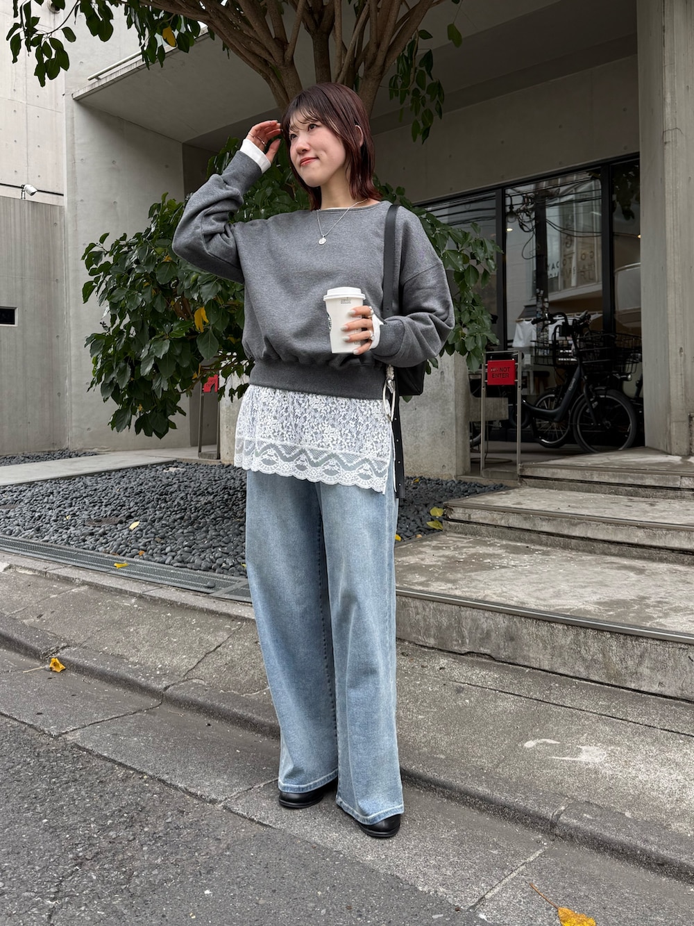 グレー系のスウェット、ホワイト系のキャミソール、ブラック系のショルダーバッグを着用したレディースの冬コーディネートの2枚目の写真