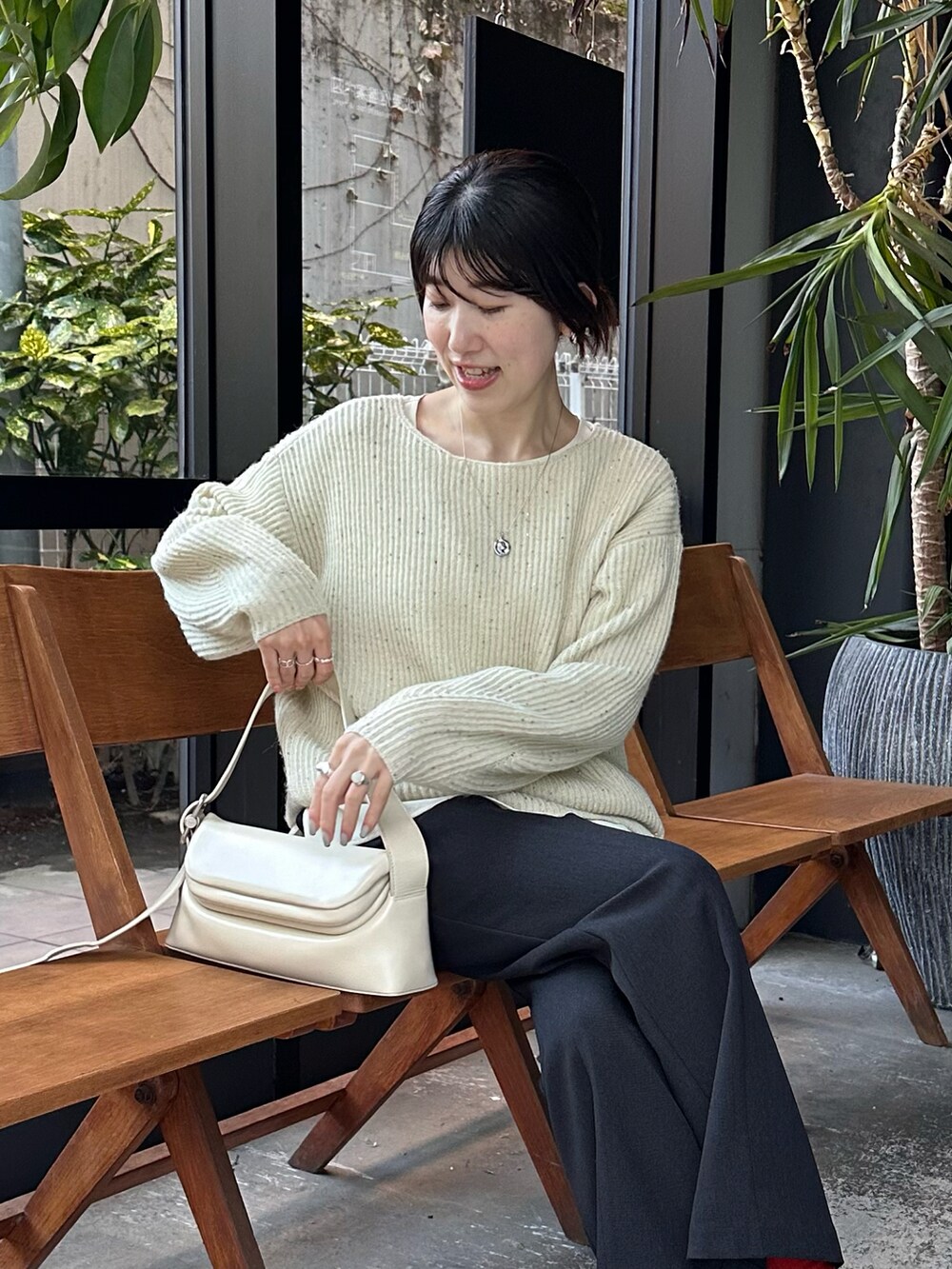 ホワイト系のニット/セーター、ブルー系のスラックス、ホワイト系のシャツ/ブラウスを着用したレディースの冬コーディネートの5枚目の写真