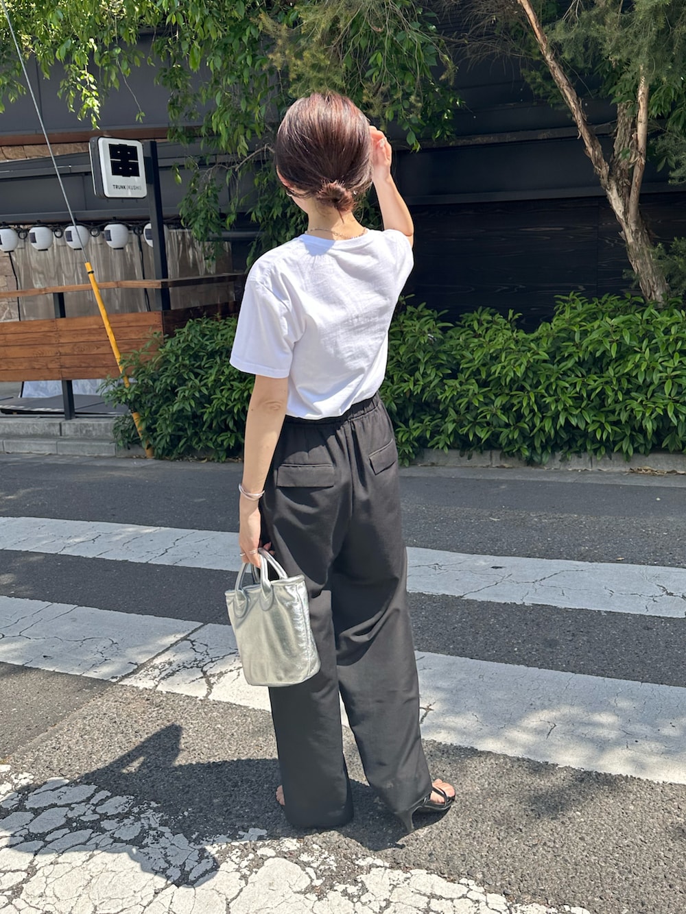 ホワイト系のTシャツ/カットソー、ブラック系のその他パンツ、シルバー系のトートバッグを着用したレディースの春コーディネートの5枚目の写真