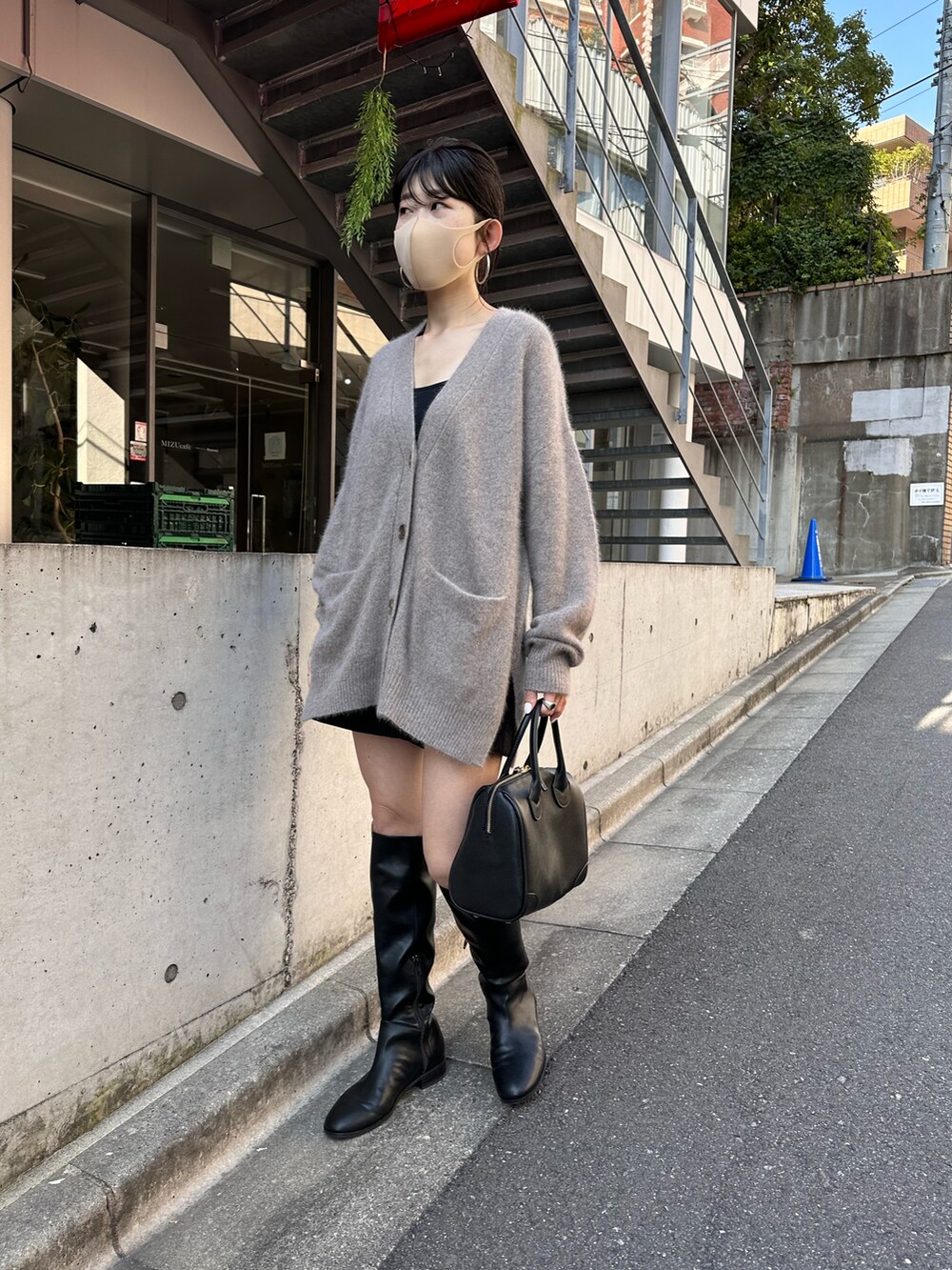 ブラウン系のカーディガン/ボレロ、ブラック系のボストンバッグ、ブラック系のブーツを着用したレディースの冬コーディネートの3枚目の写真