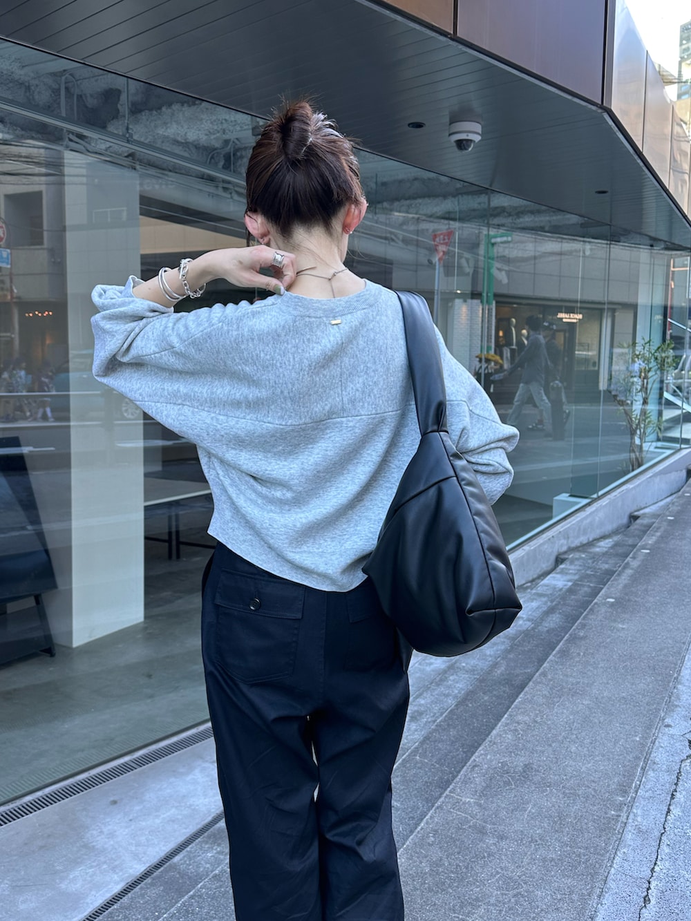 グレー系のニット/セーター、ブラック系のカーゴパンツ、シルバー系のネックレスを着用したレディースの秋コーディネートの3枚目の写真