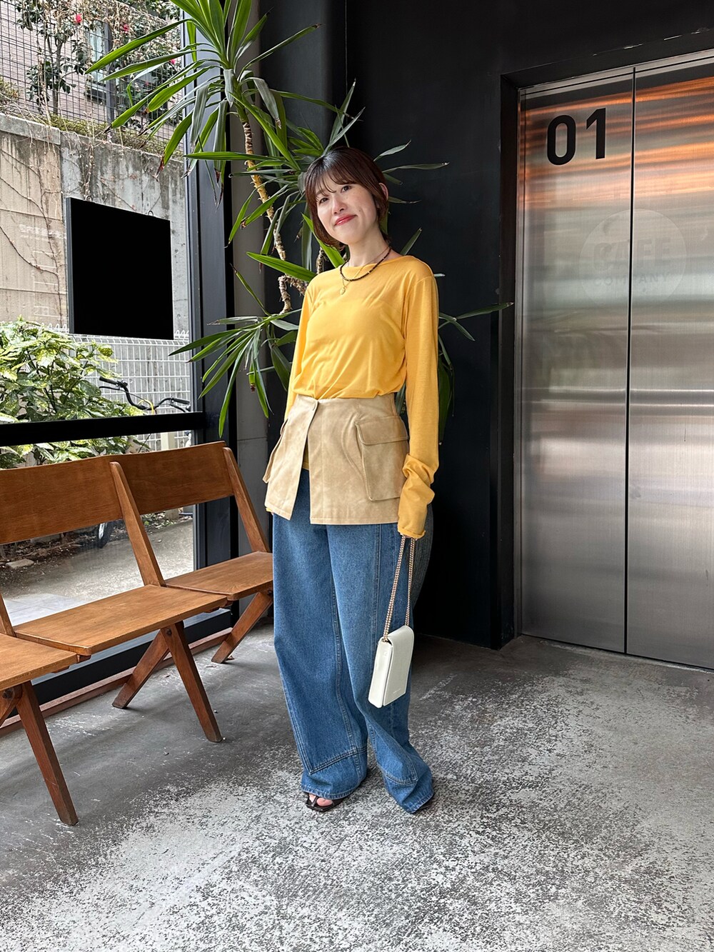 イエロー系のTシャツ/カットソー、ブラック系のデニムパンツを着用したレディースの春コーディネートの3枚目の写真