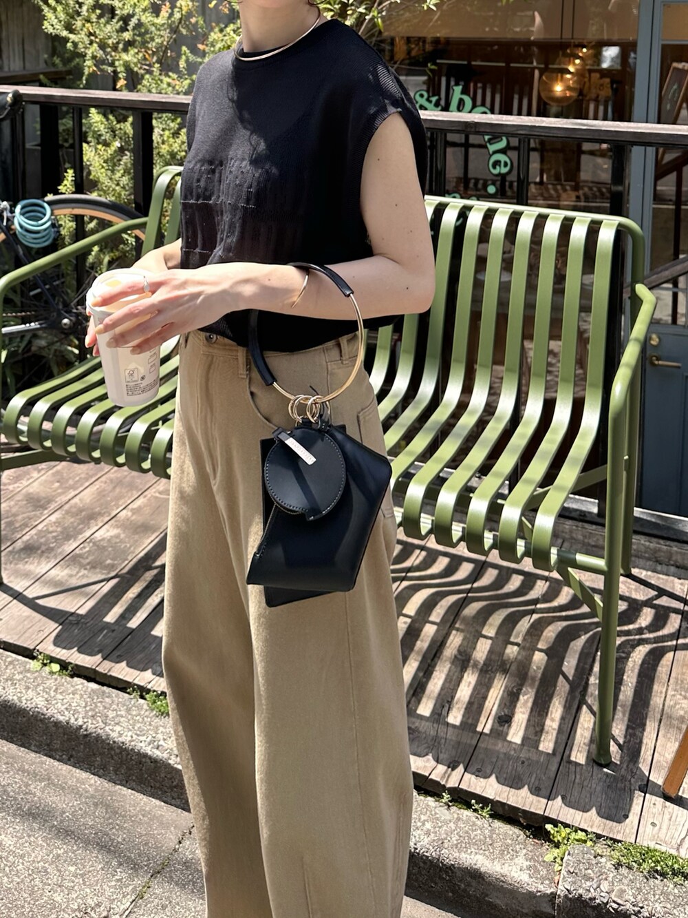 ブラック系のニット/セーター、ホワイト系のバッグ、ベージュ系のデニムパンツを着用したレディースの春コーディネートの2枚目の写真