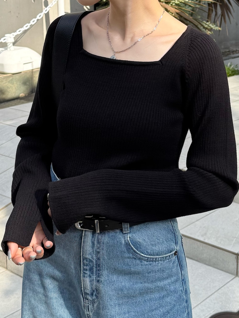 ブルー系のデニムパンツ、ブラック系のニット/セーター、ブラック系のパンプスを着用したレディースの秋コーディネートの6枚目の写真