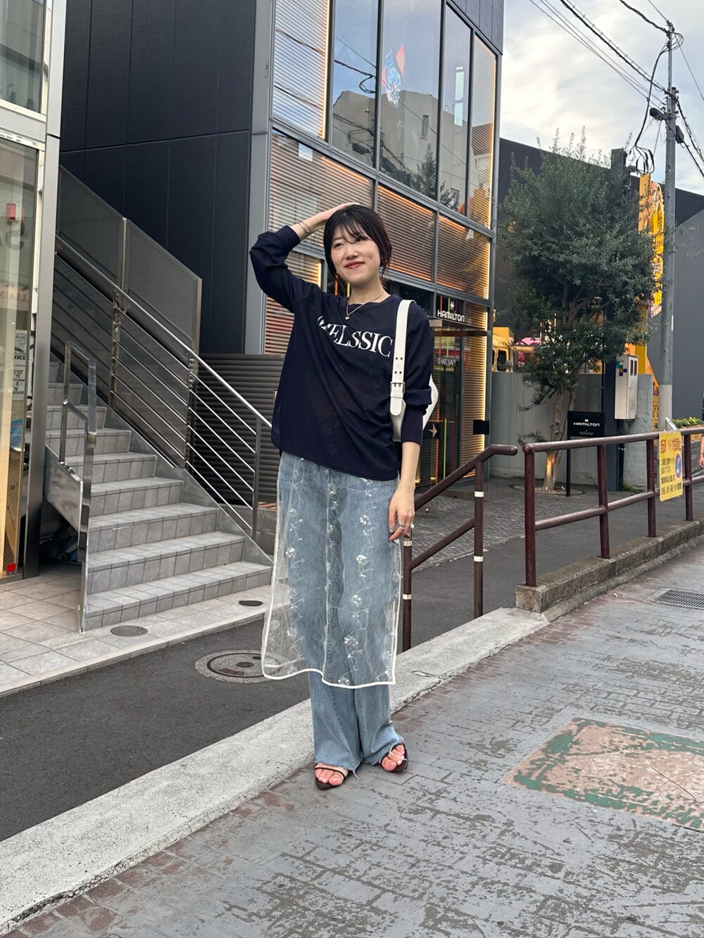 ブルー系のTシャツ/カットソー、ブルー系のデニムパンツ、ホワイト系のワンピースを着用したレディースの夏コーディネートの3枚目の写真