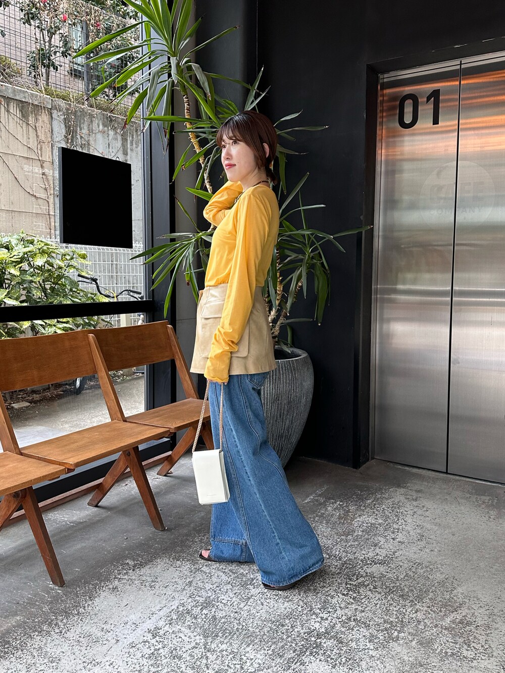 イエロー系のTシャツ/カットソー、ブラック系のデニムパンツを着用したレディースの春コーディネートの2枚目の写真