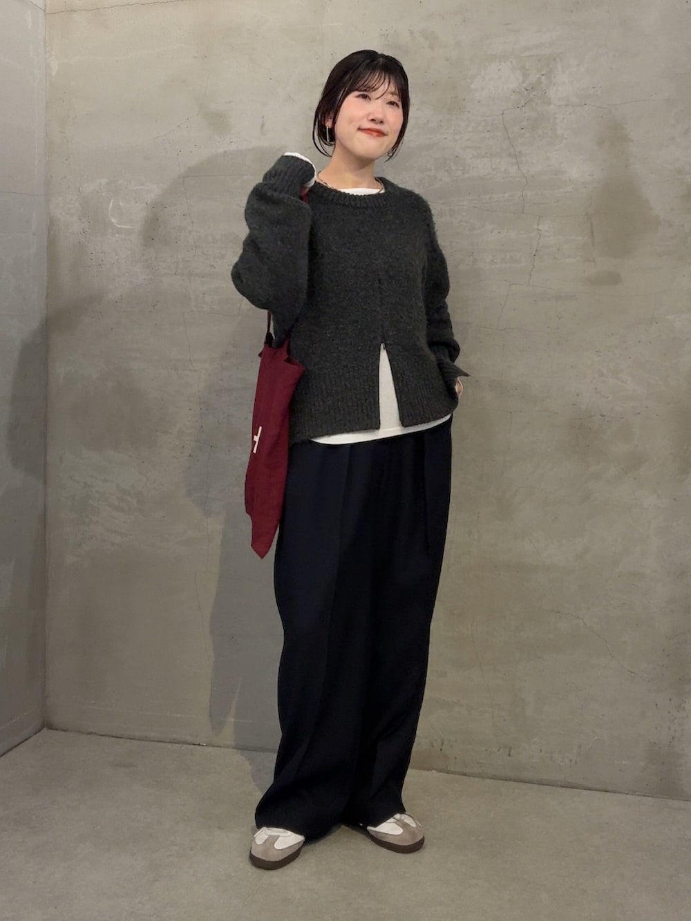 グレー系のニット/セーター、ホワイト系のTシャツ/カットソー、ブルー系のスラックスを着用したレディースの冬コーディネートの4枚目の写真