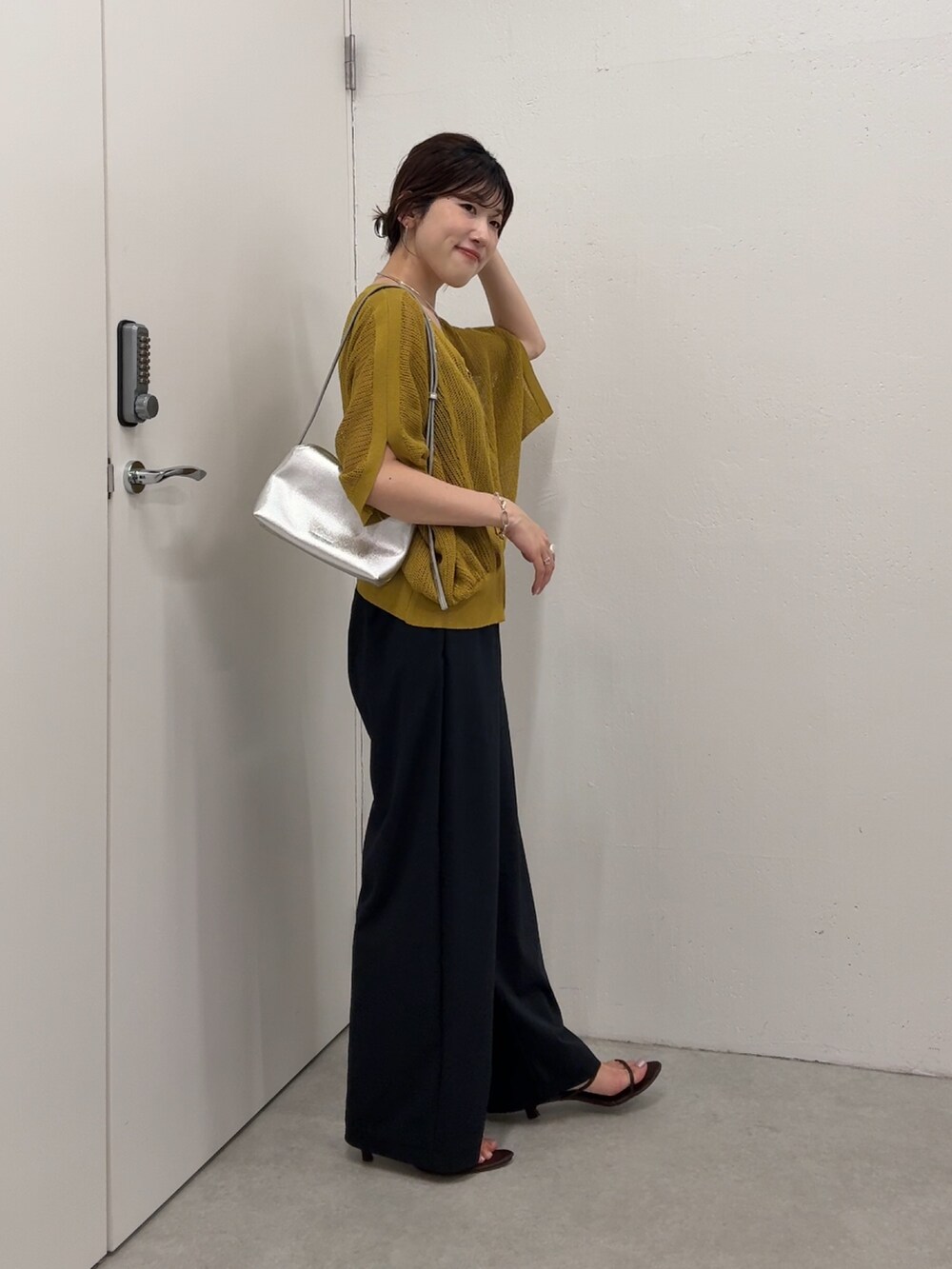 イエロー系のカーディガン/ボレロ、ブラック系のその他パンツ、シルバー系のショルダーバッグを着用したレディースの夏コーディネートの3枚目の写真